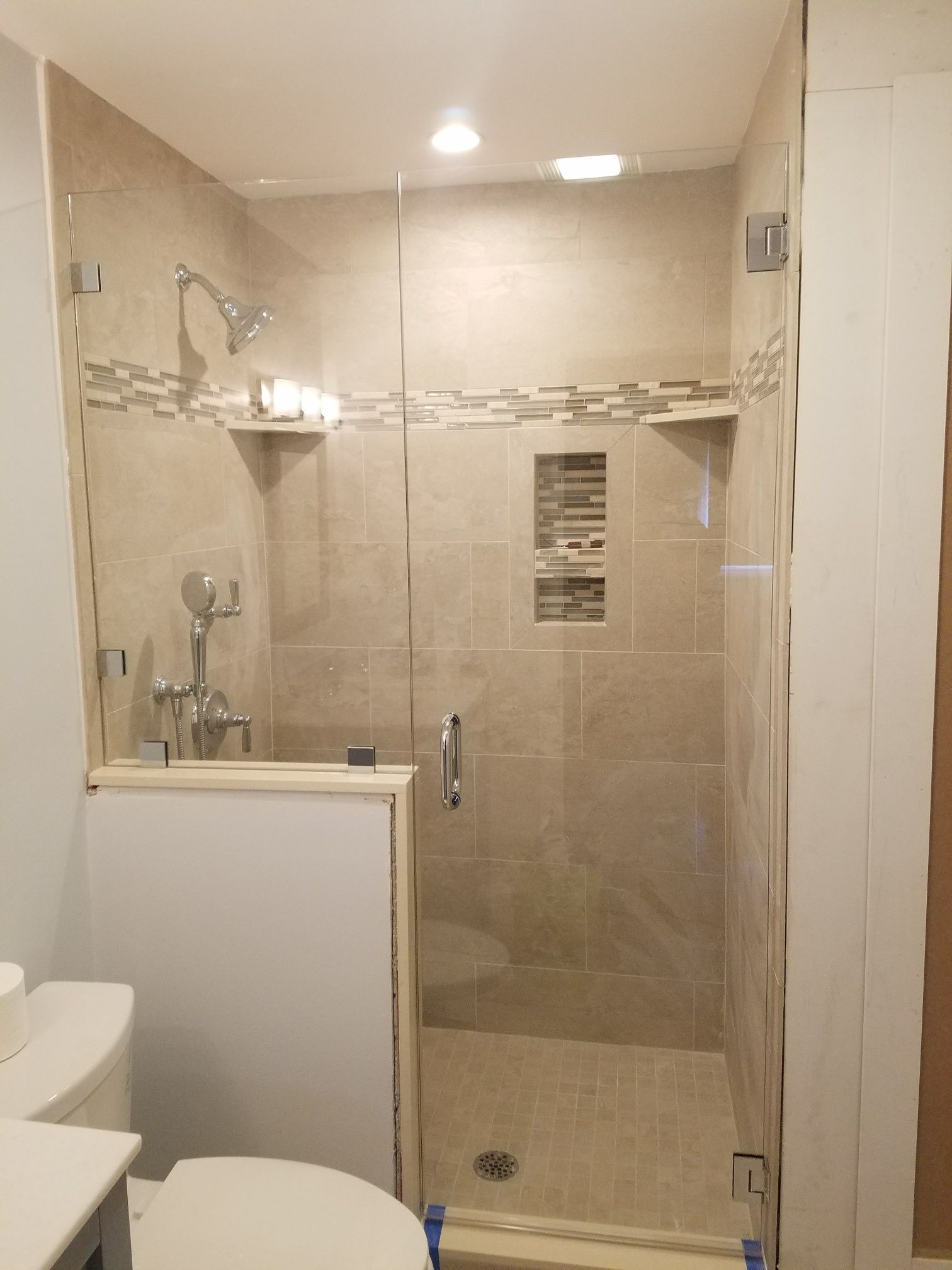 A bathroom with a walk in shower and a toilet.