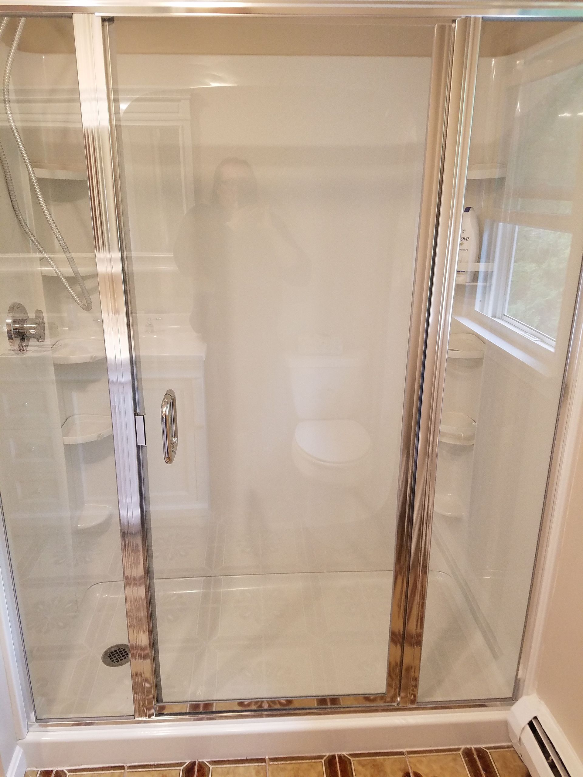 A bathroom with a shower stall and a toilet.