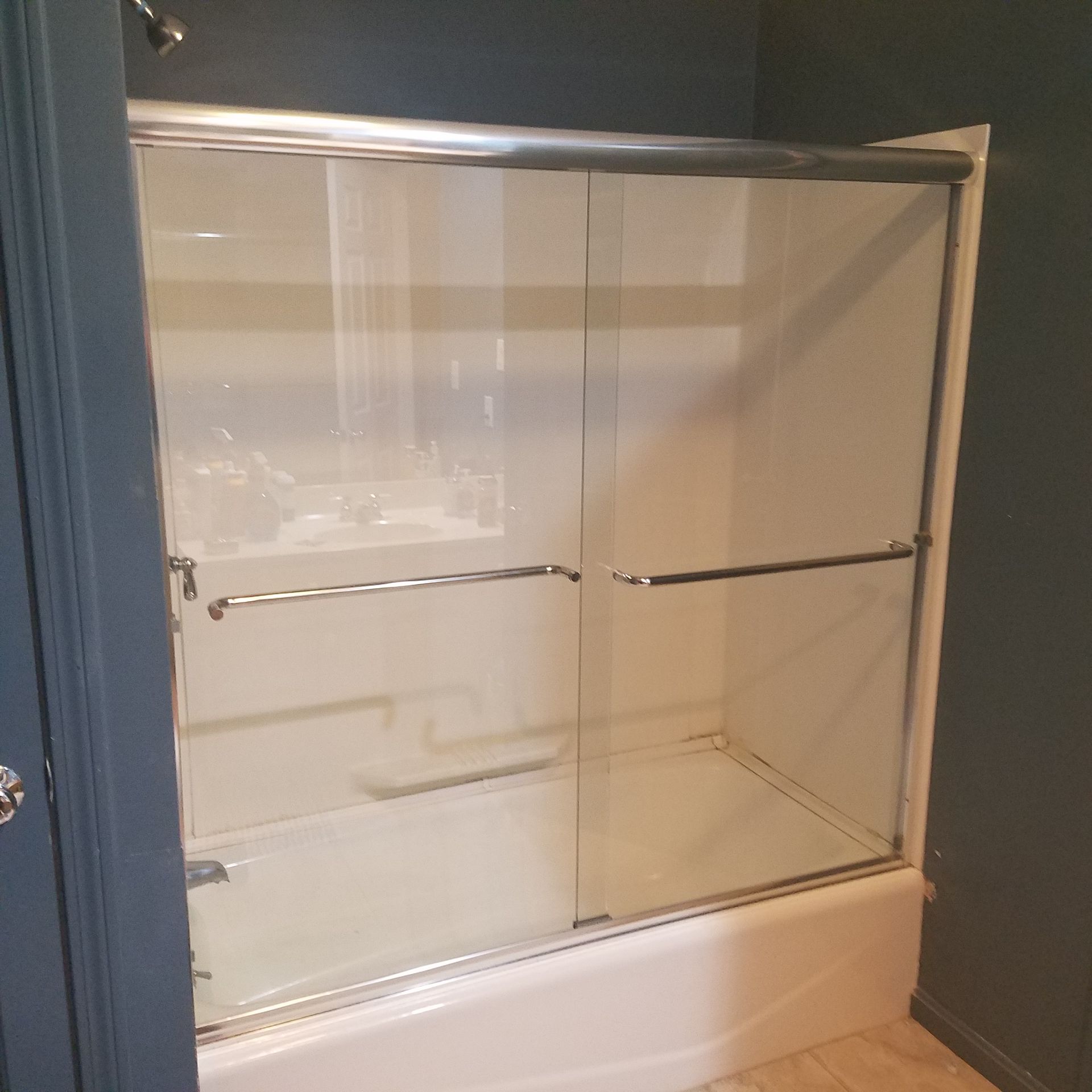 A bathroom with a sliding glass shower door and a bathtub.