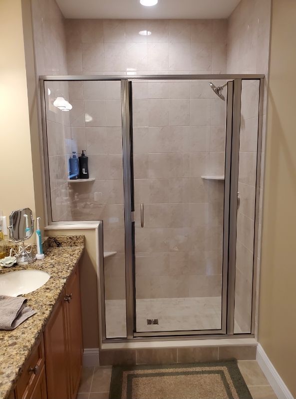 A bathroom with a walk in shower and a sink.