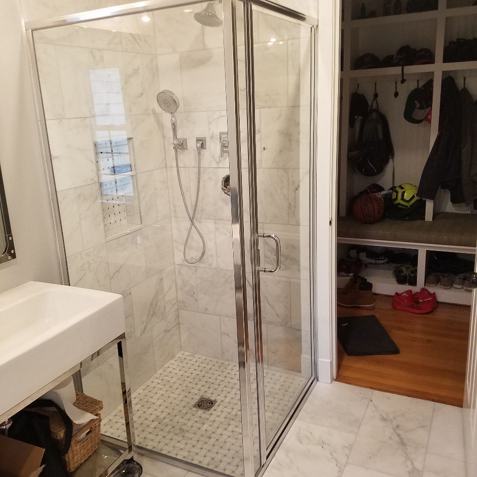 A bathroom with a walk in shower and a sink.