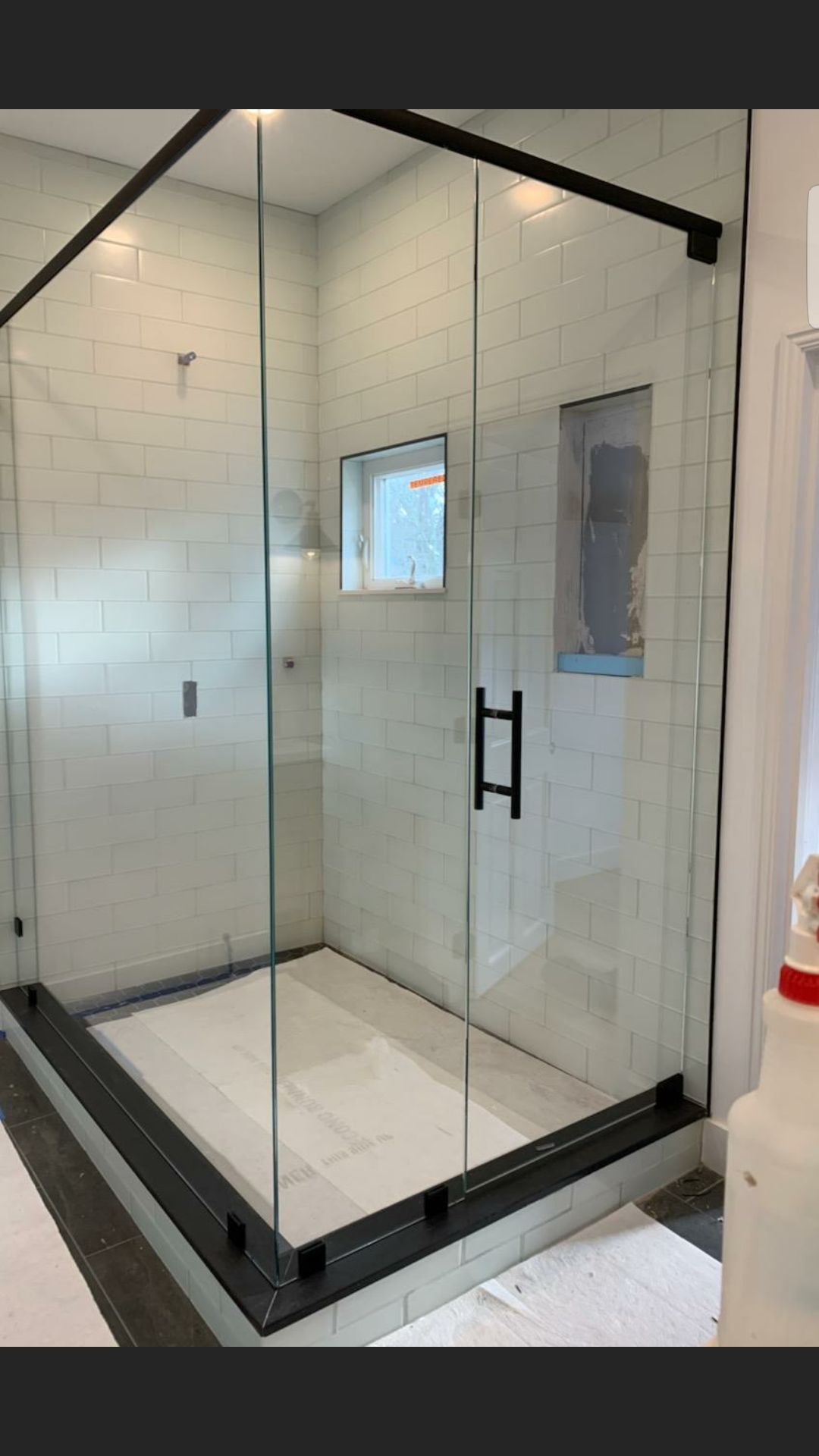 A bathroom with a walk in shower with sliding glass doors.