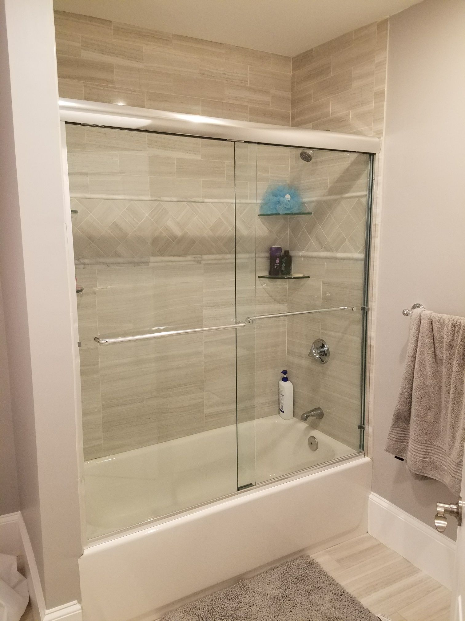 A bathroom with a bathtub and a sliding glass shower door.