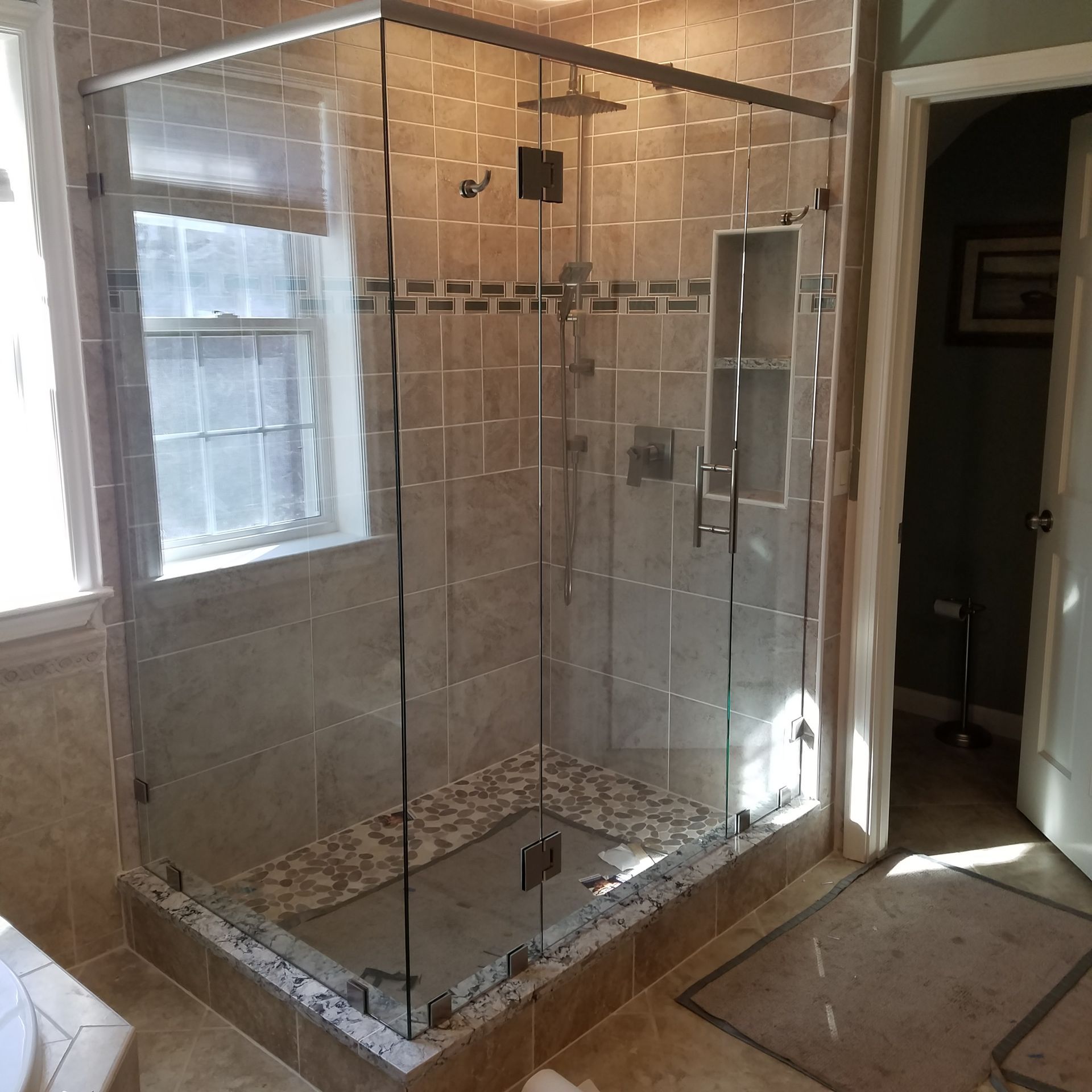 A bathroom with a walk in shower and a window