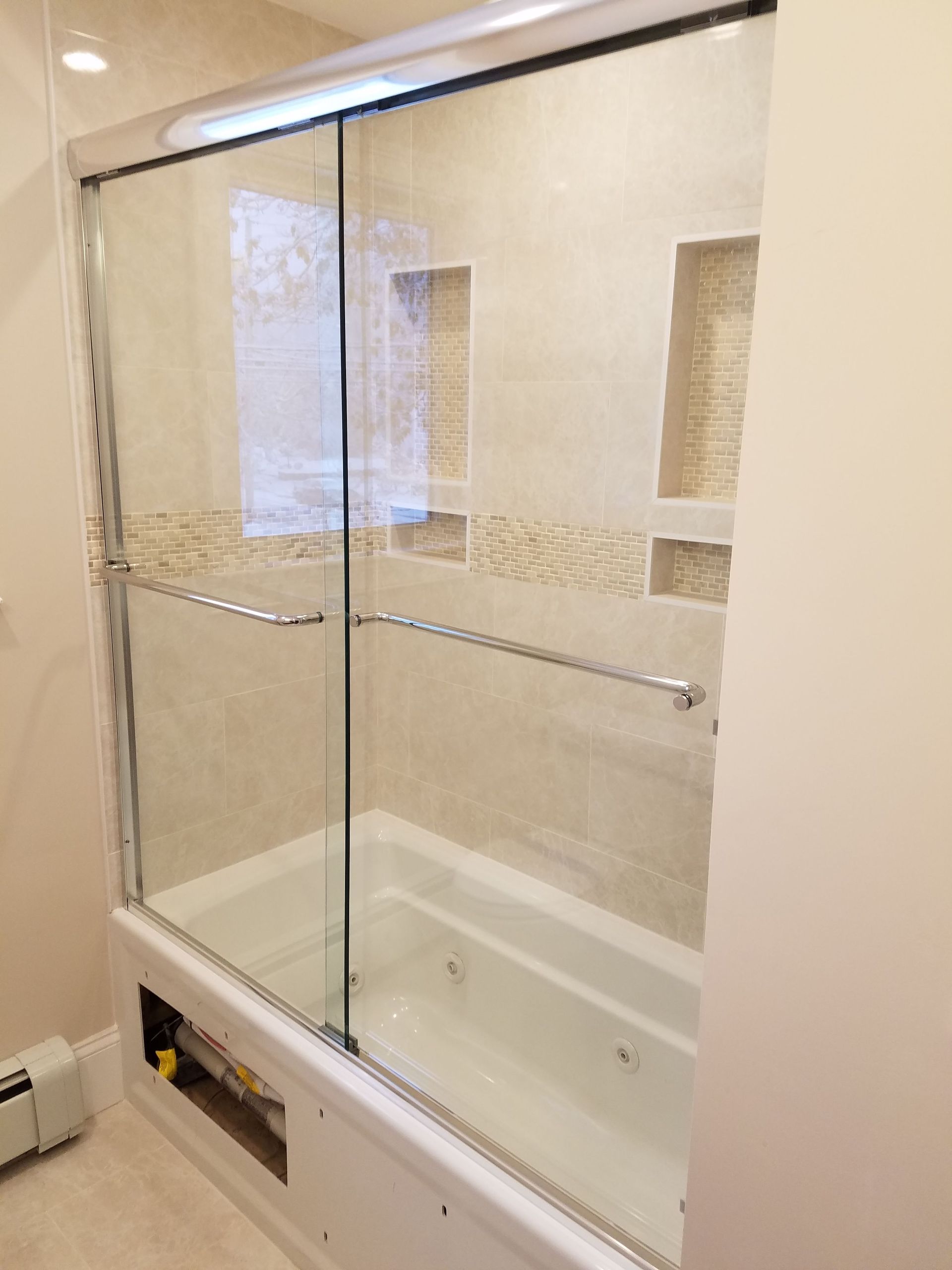 A bathroom with a bathtub and a sliding glass shower door.