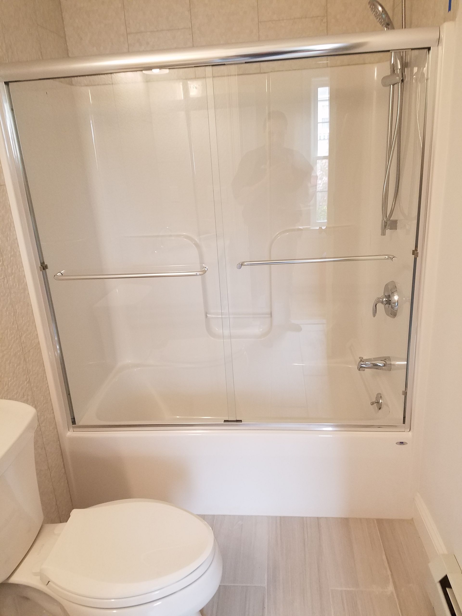 A bathroom with a toilet a tub and a shower