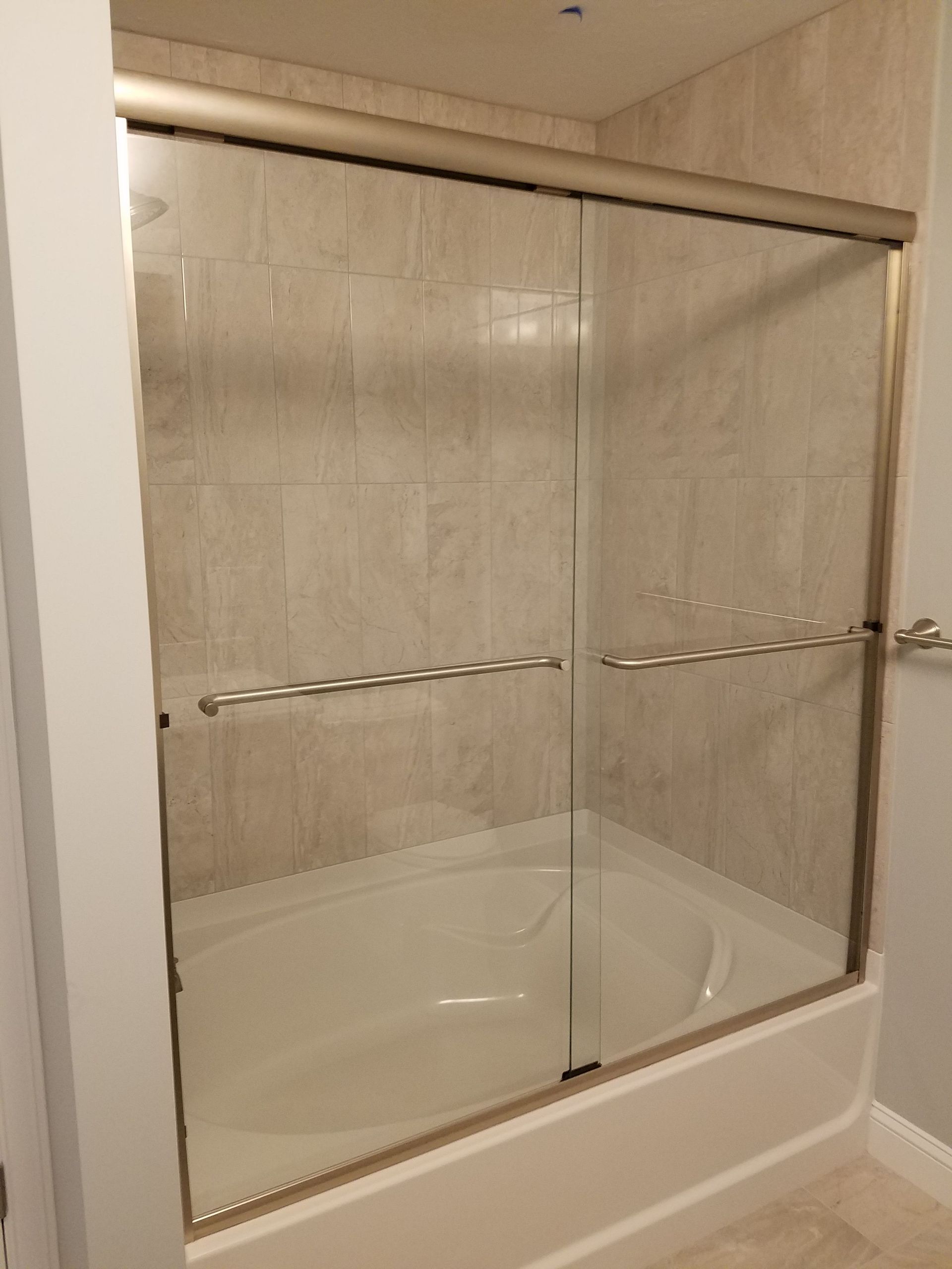 A bathroom with a bathtub and a sliding glass shower door.