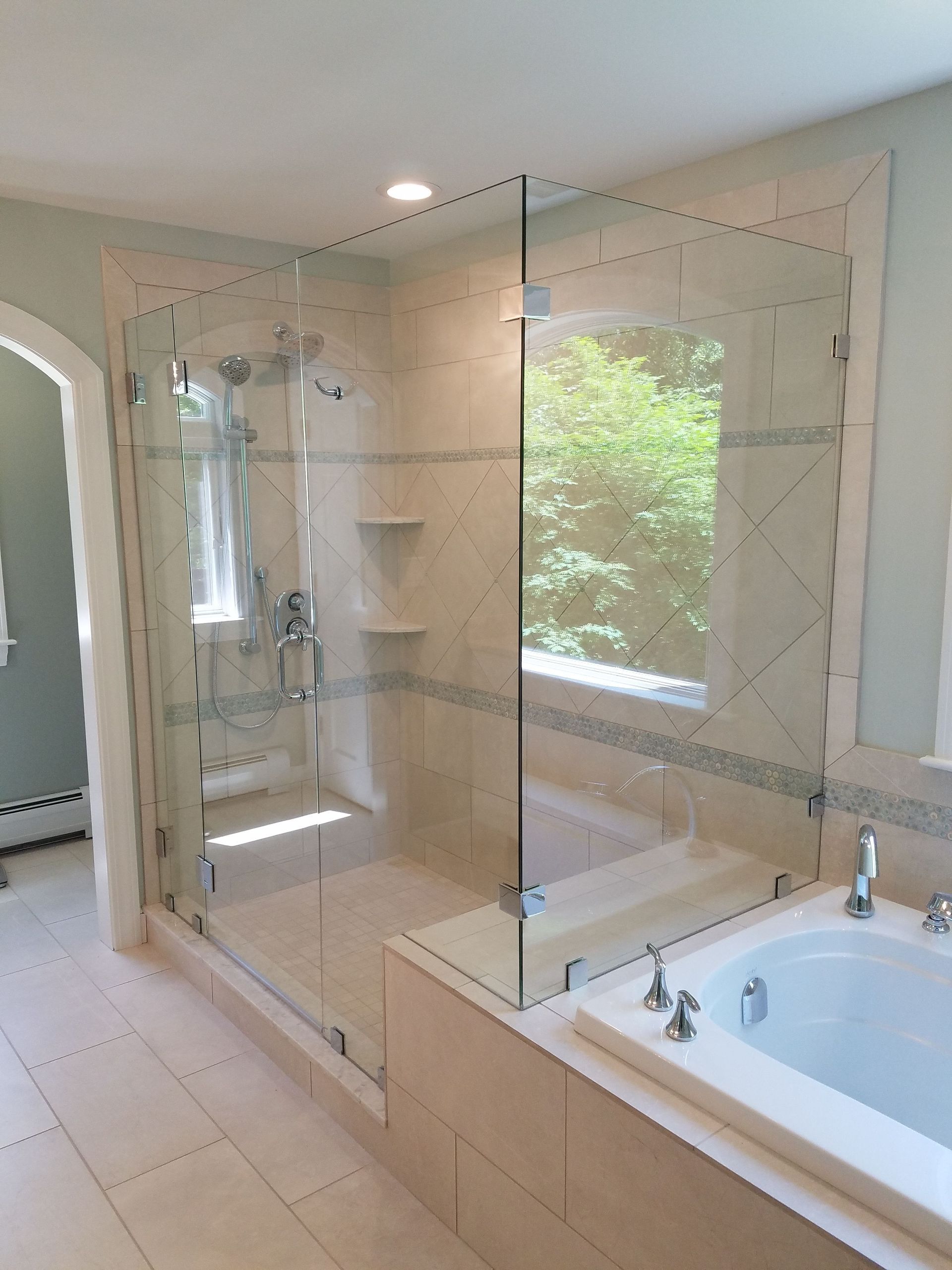 A bathroom with a walk in shower and a bathtub.