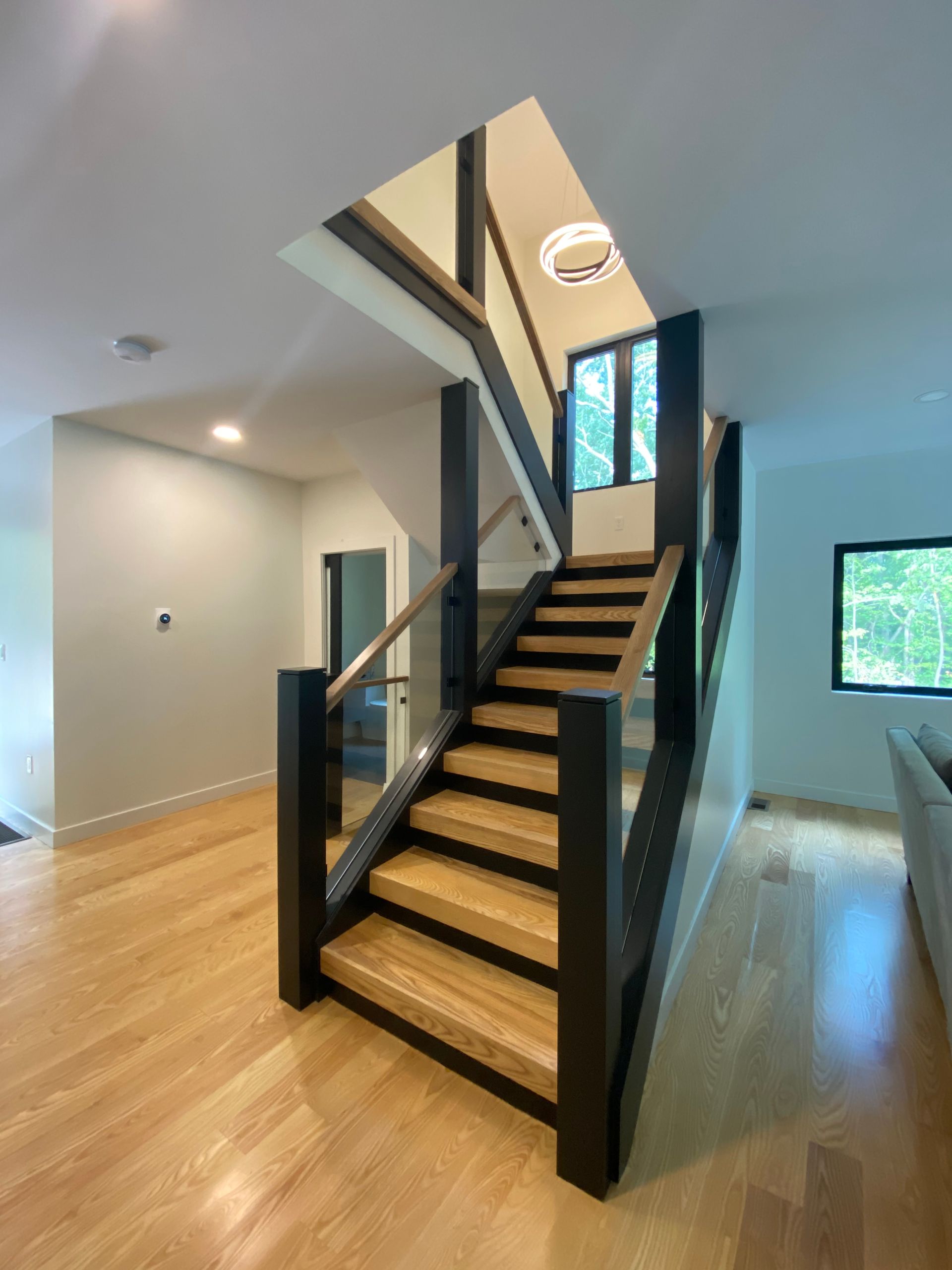 A wooden staircase with a glass railing in a house