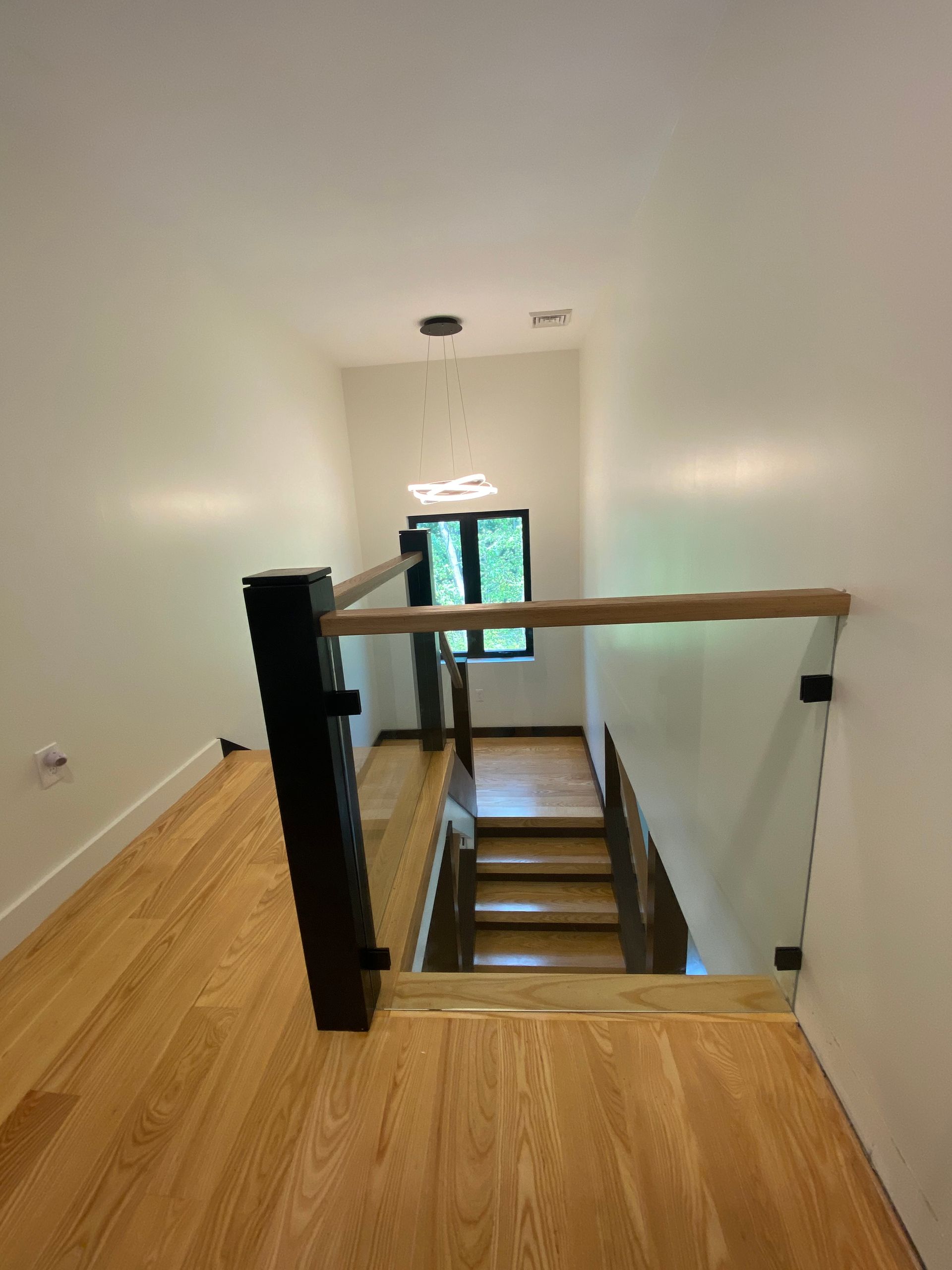 A staircase with wooden steps and a glass railing in a house.