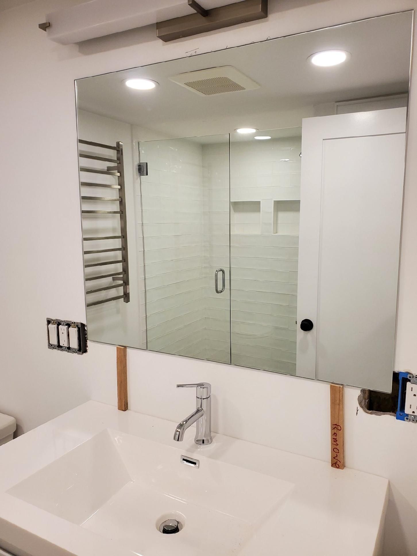 A bathroom with a sink and a large mirror.