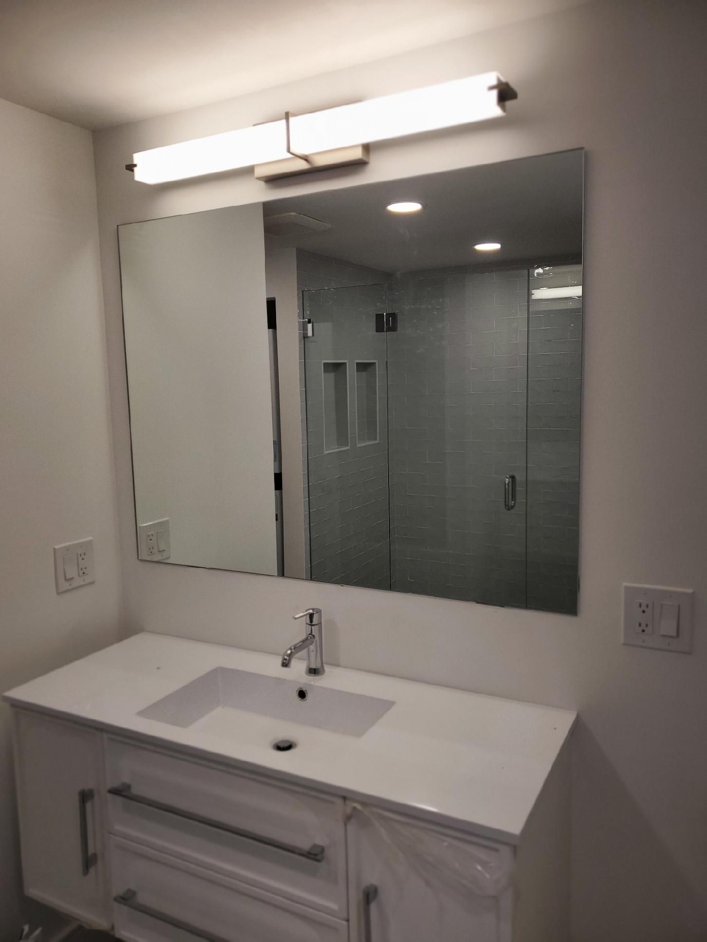 A bathroom with a sink and a large mirror