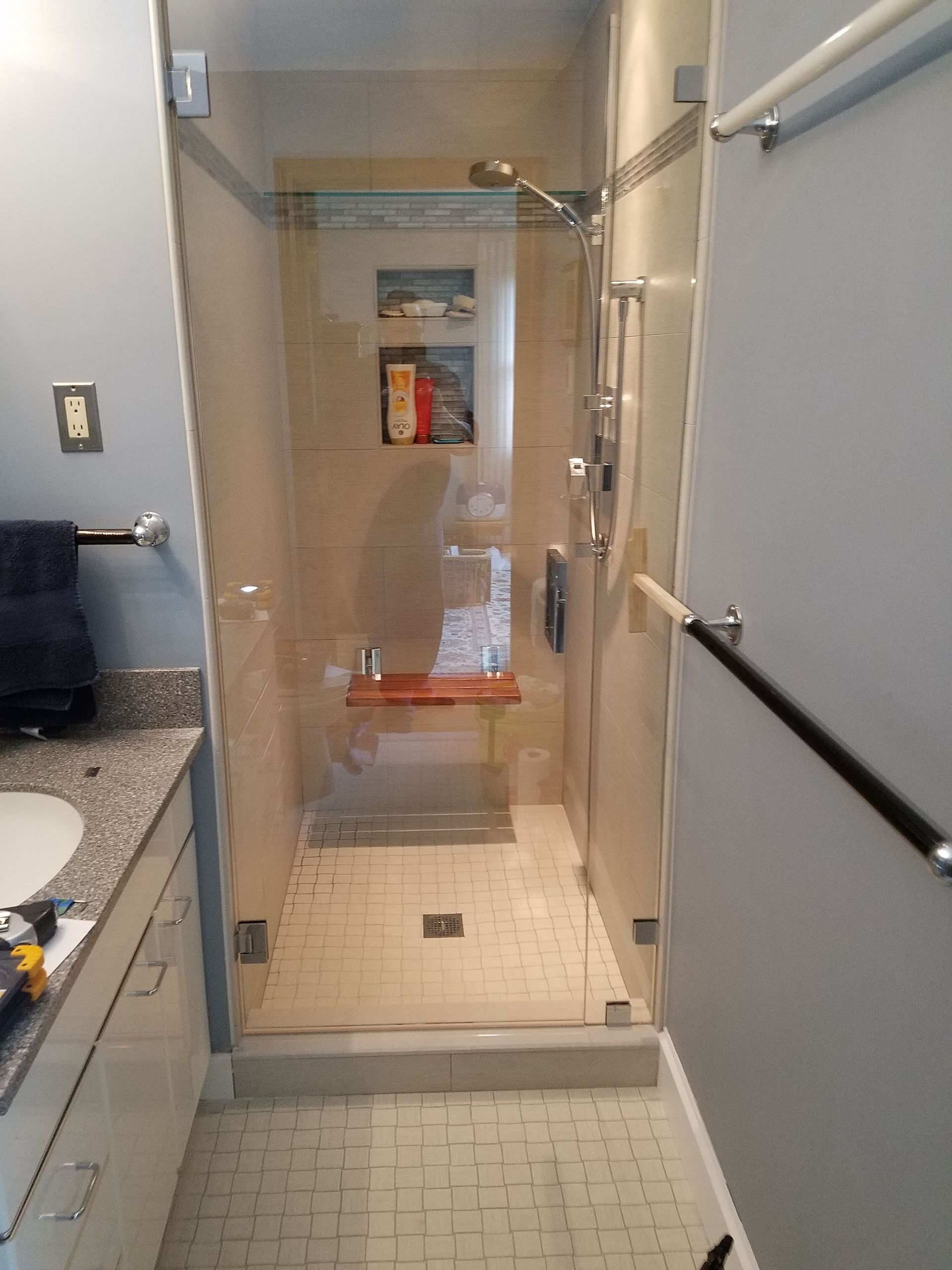 A bathroom with a walk in shower and a sink.
