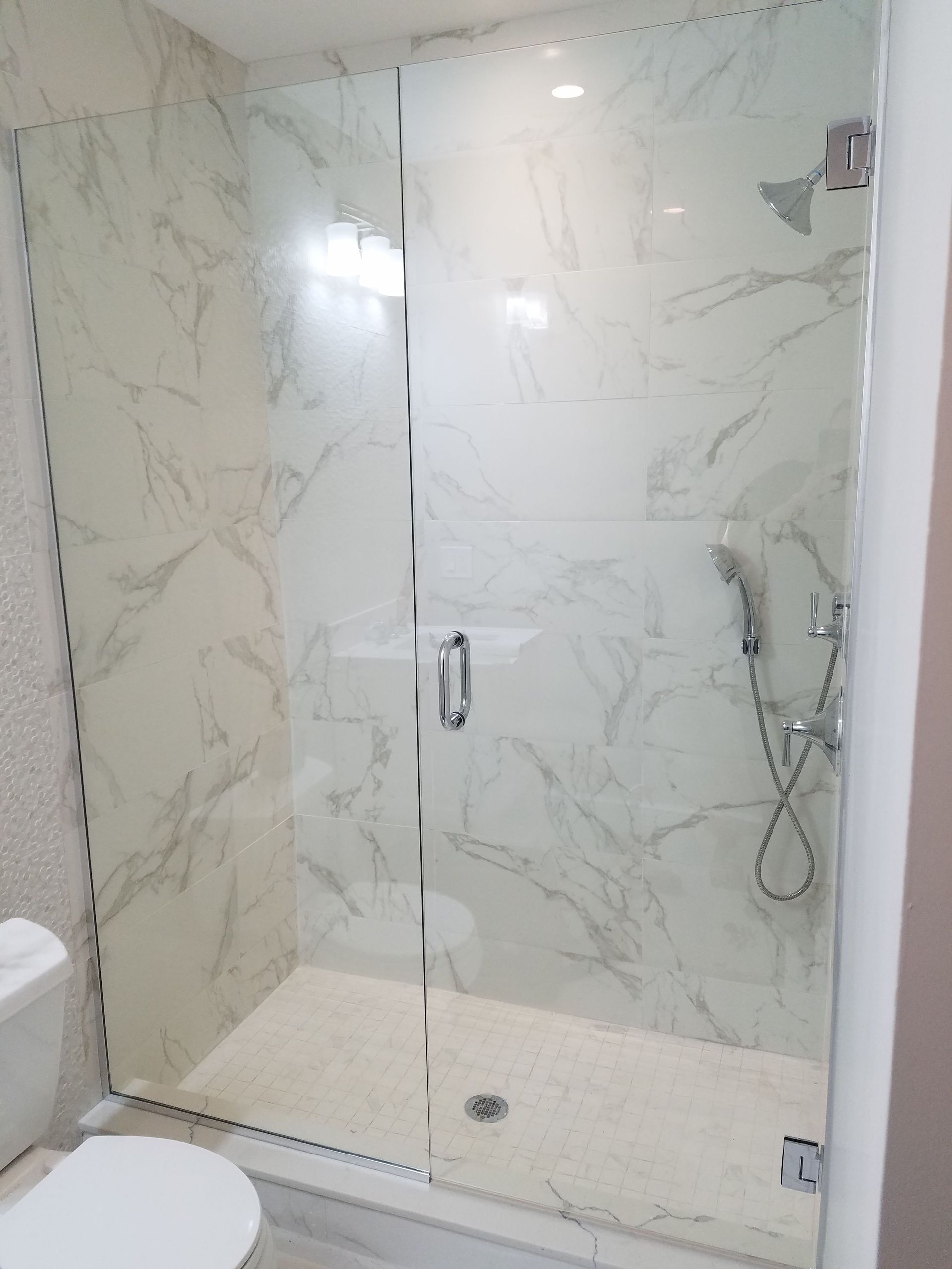 A bathroom with a walk in shower and a toilet.