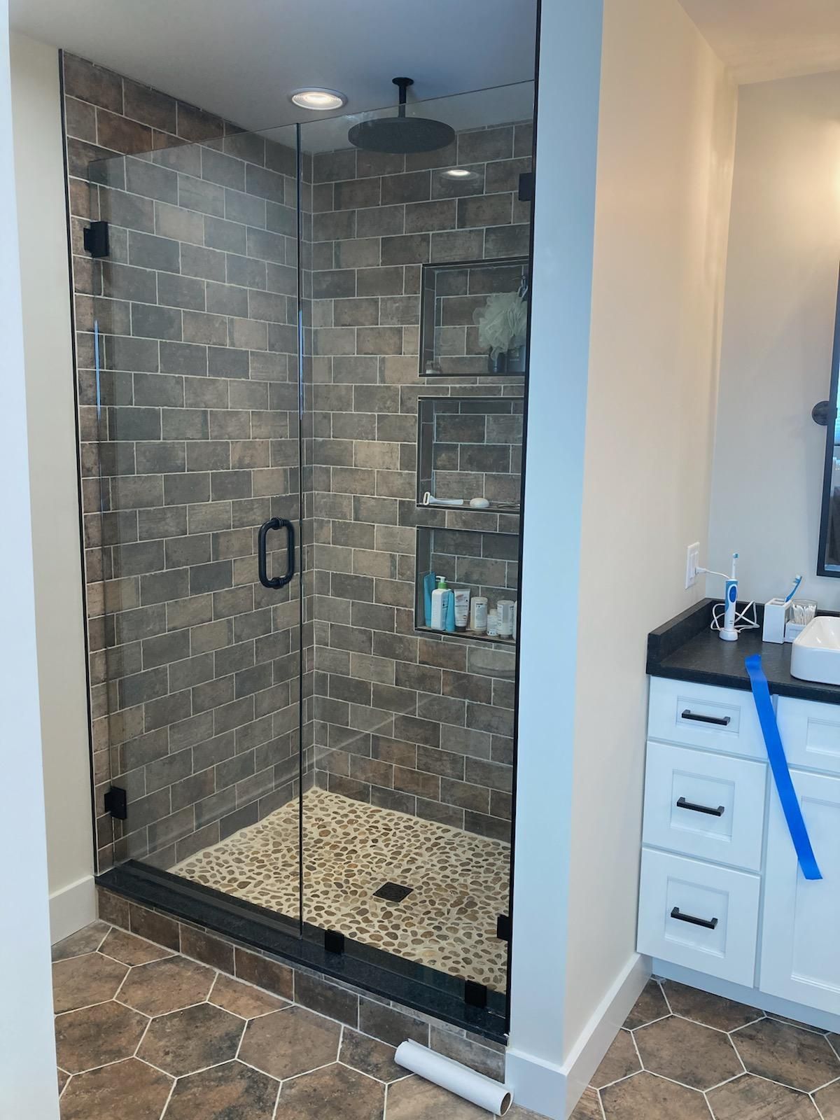 A bathroom with a walk in shower and a sink.