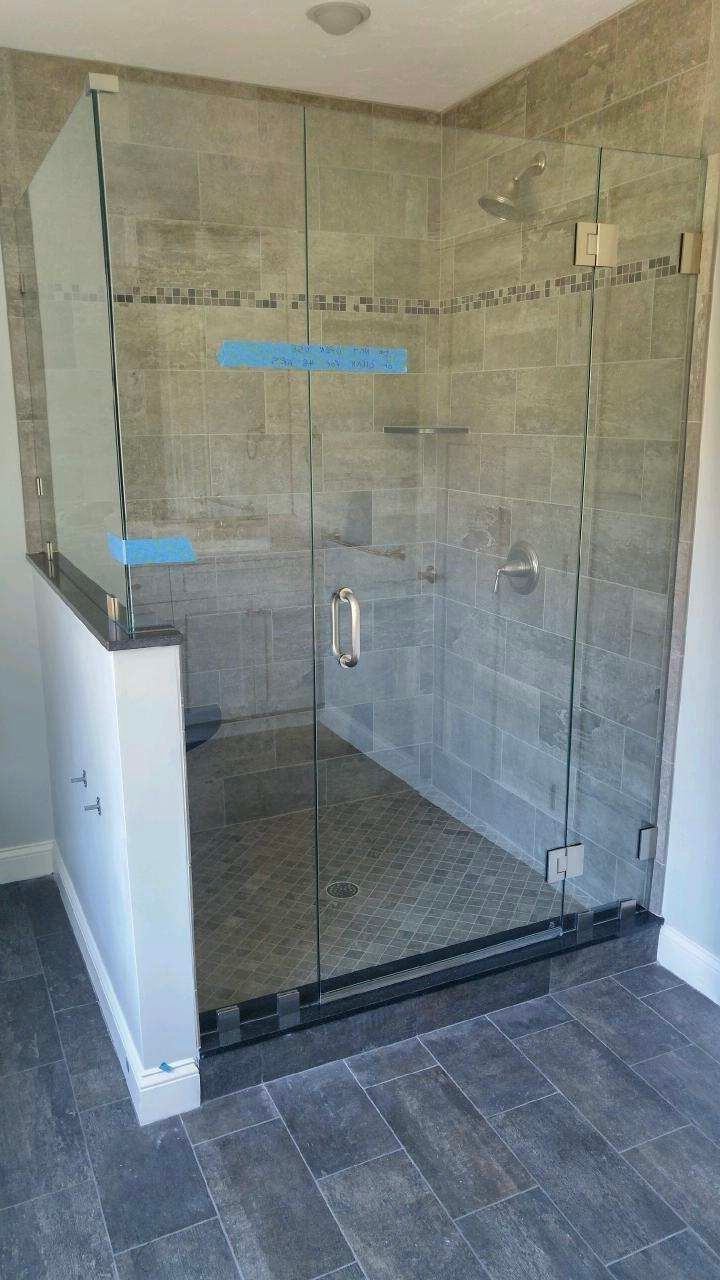A bathroom with a walk in shower with a glass door.