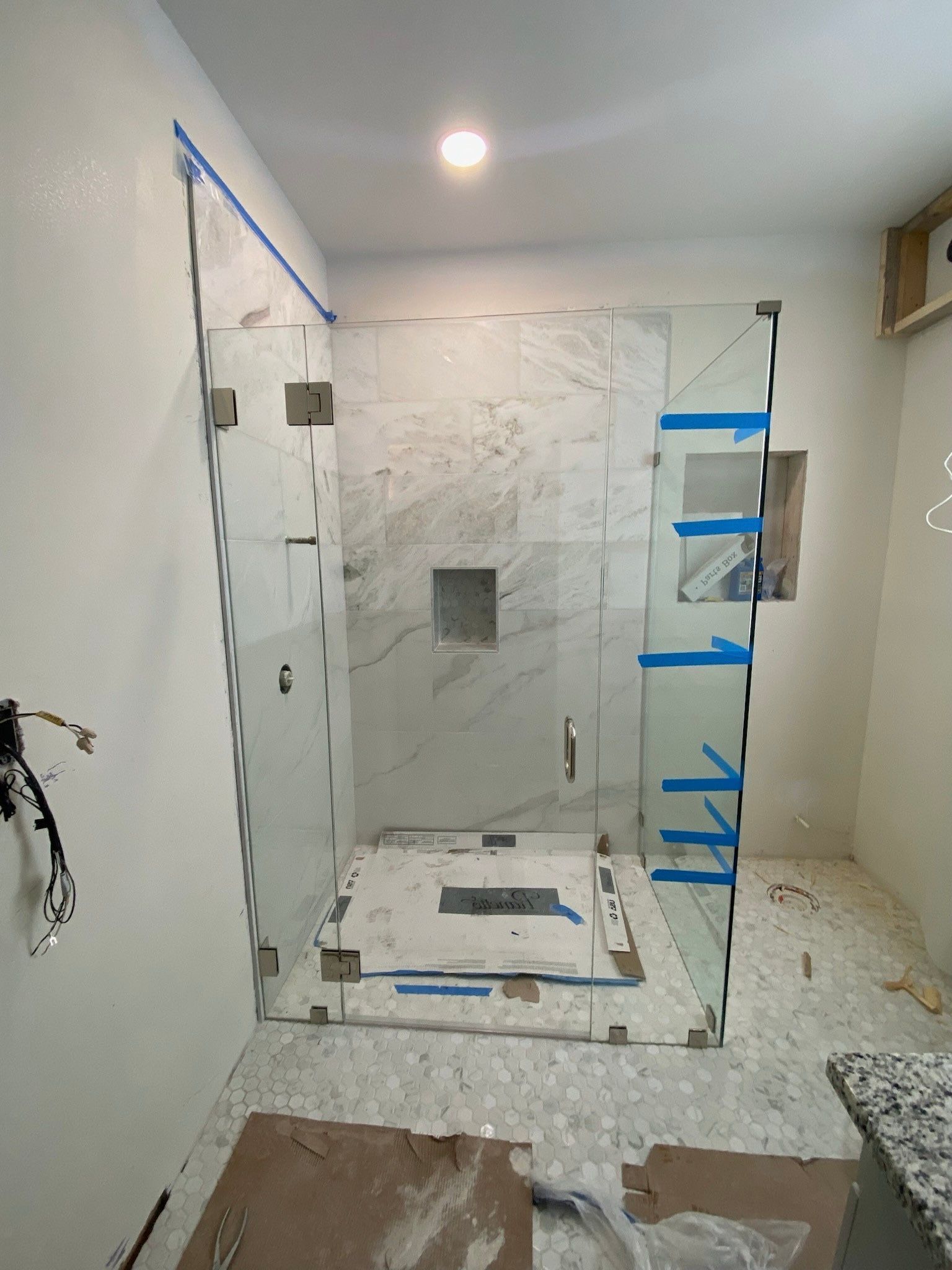 A bathroom with a walk in shower being built.