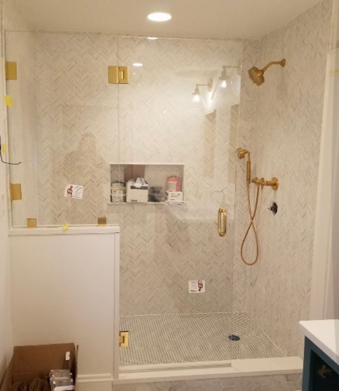 A bathroom with a glass shower door and a shower head.