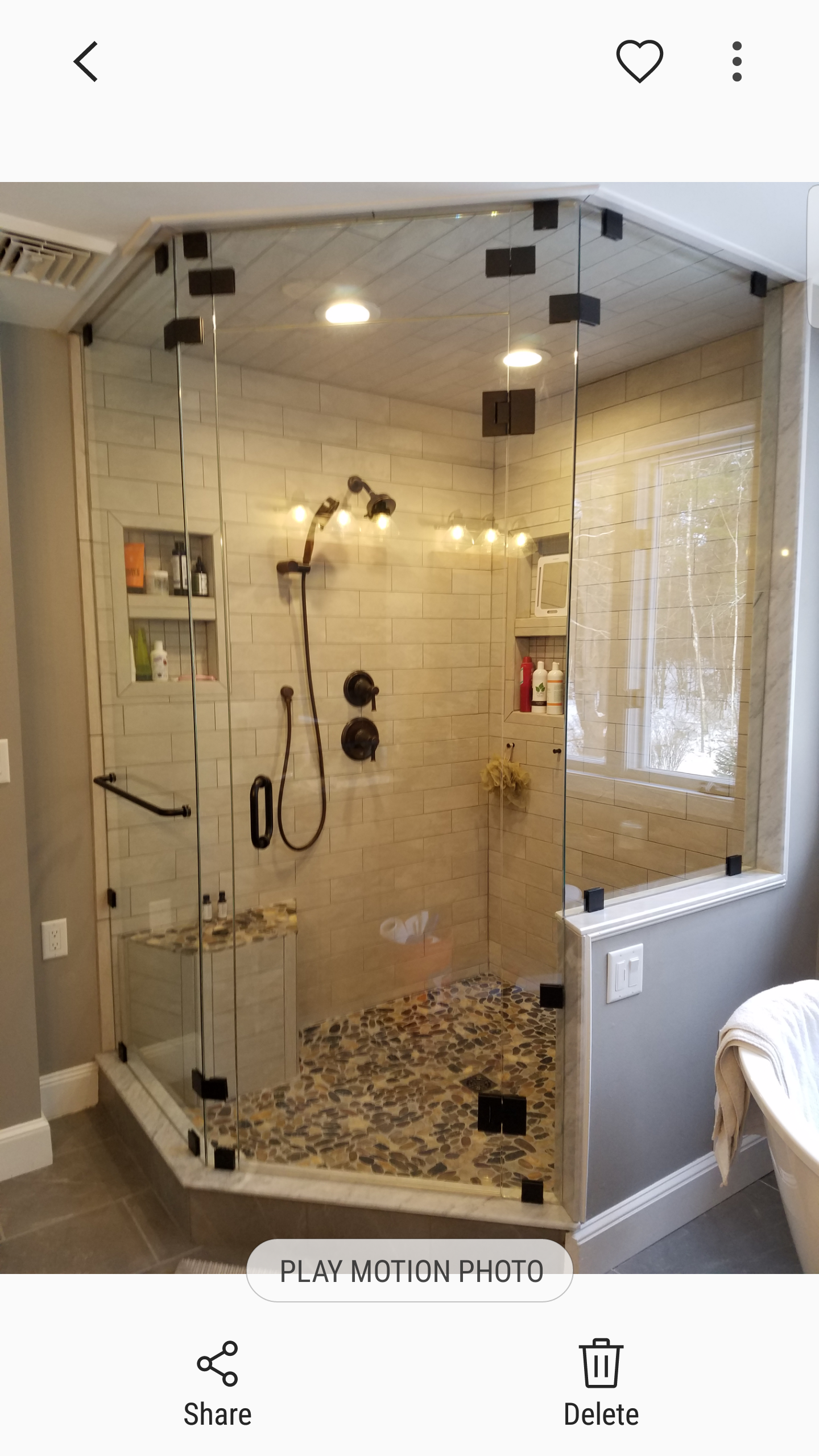 A bathroom with a walk in shower with a glass door.