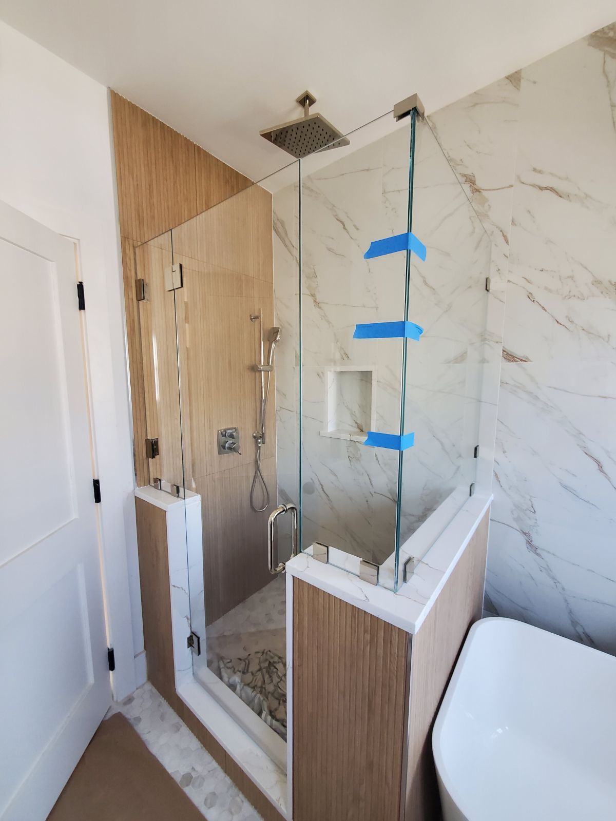 A bathroom with a walk in shower and a bathtub.