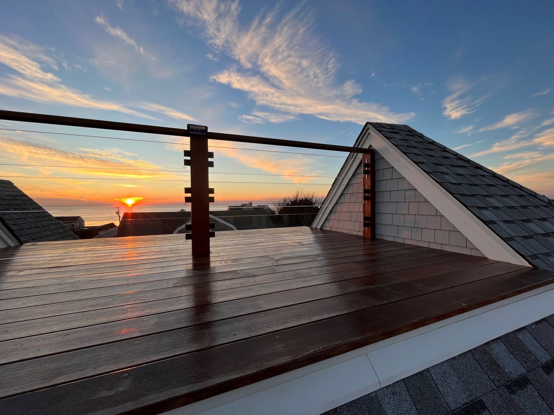 A rooftop deck with a sunset in the background