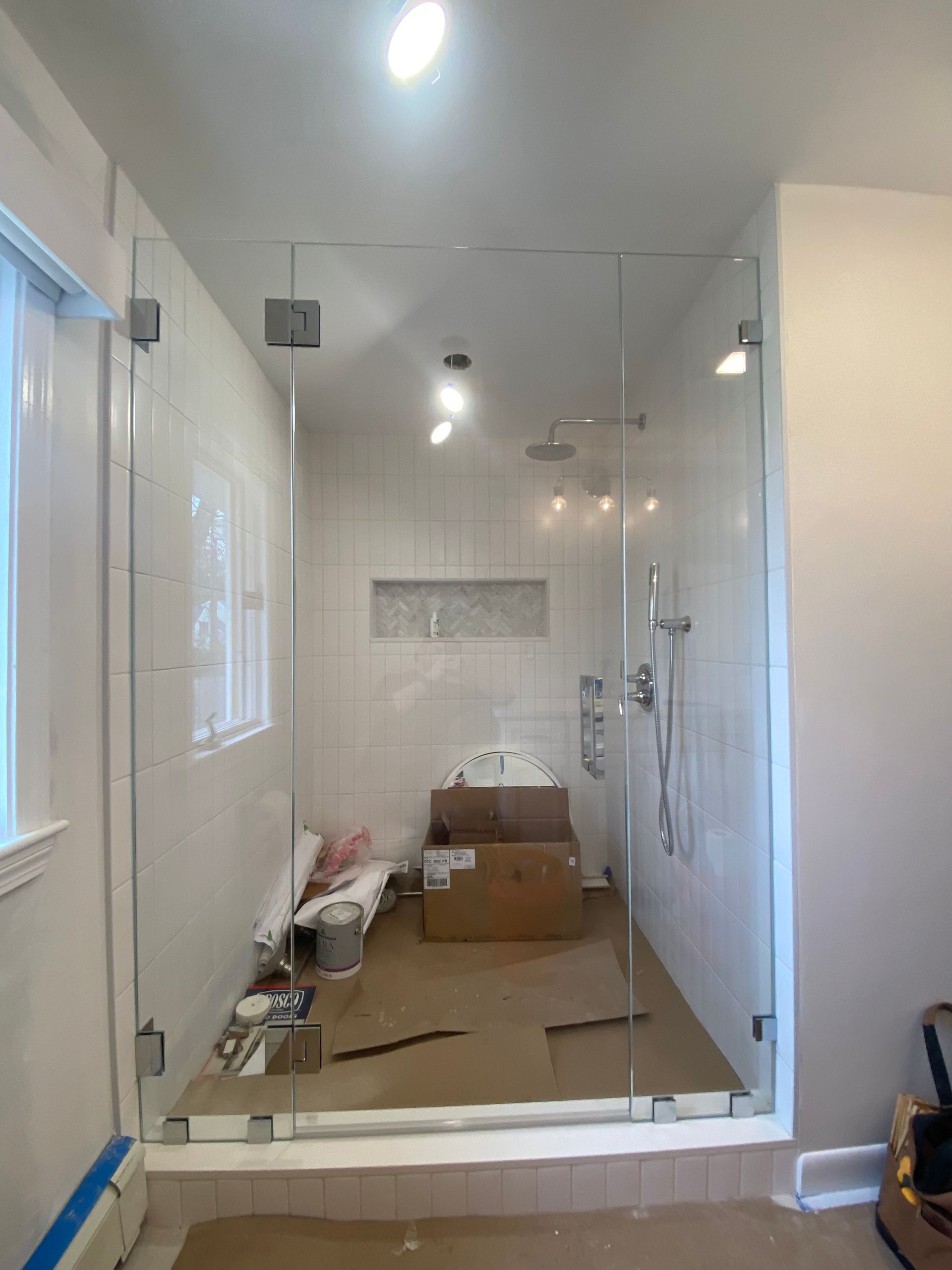 A bathroom with a bathtub and a glass shower door