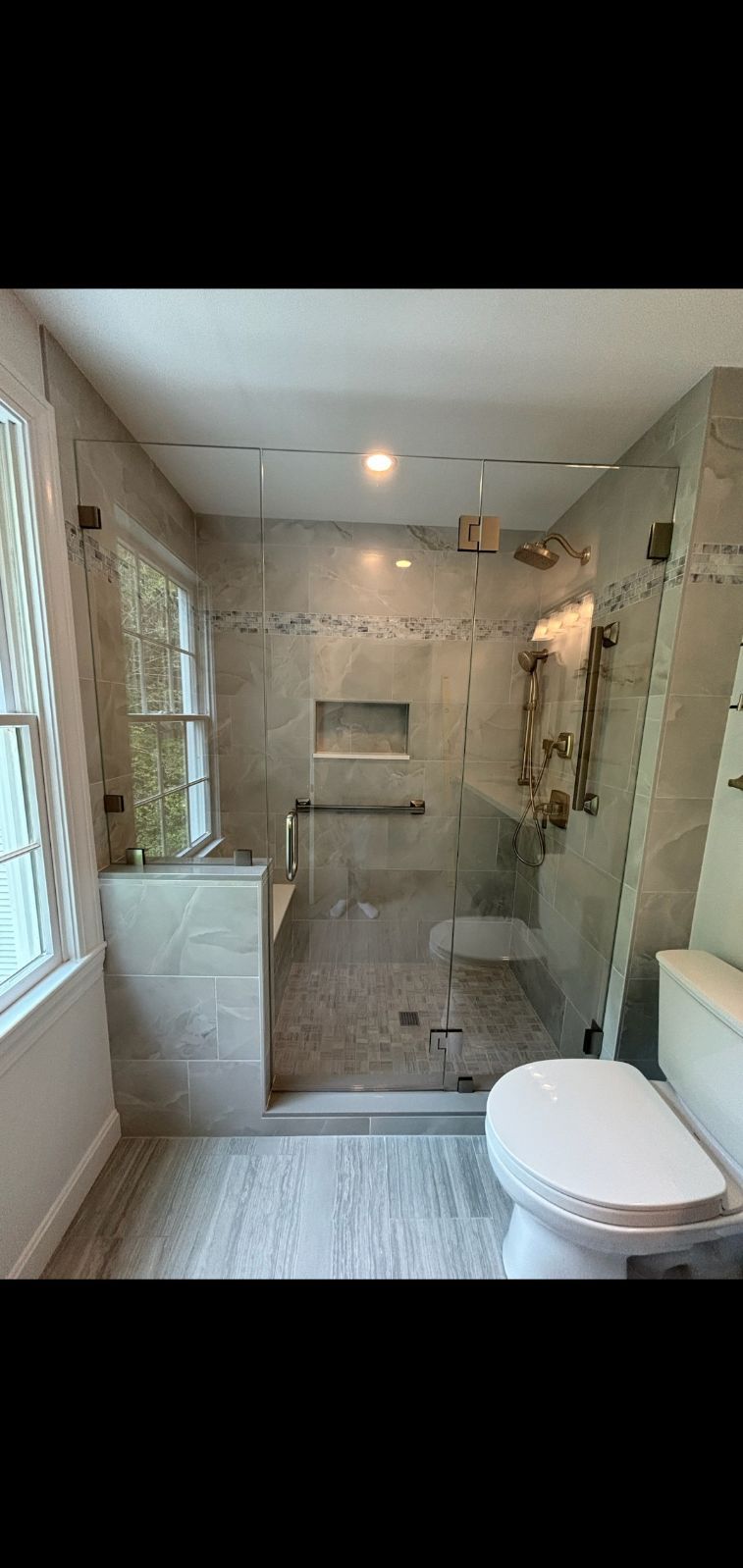 A bathroom with a walk in shower and a toilet.