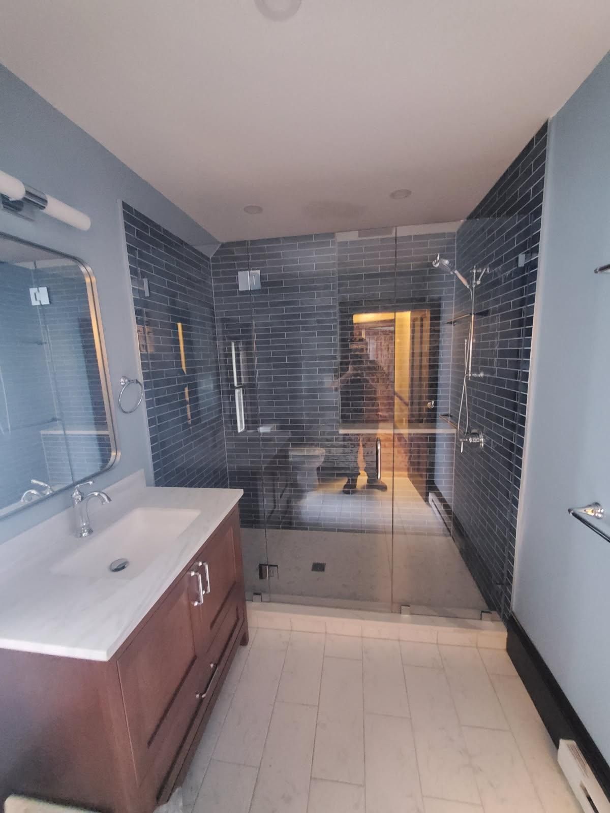 A bathroom with a sink and a walk in shower