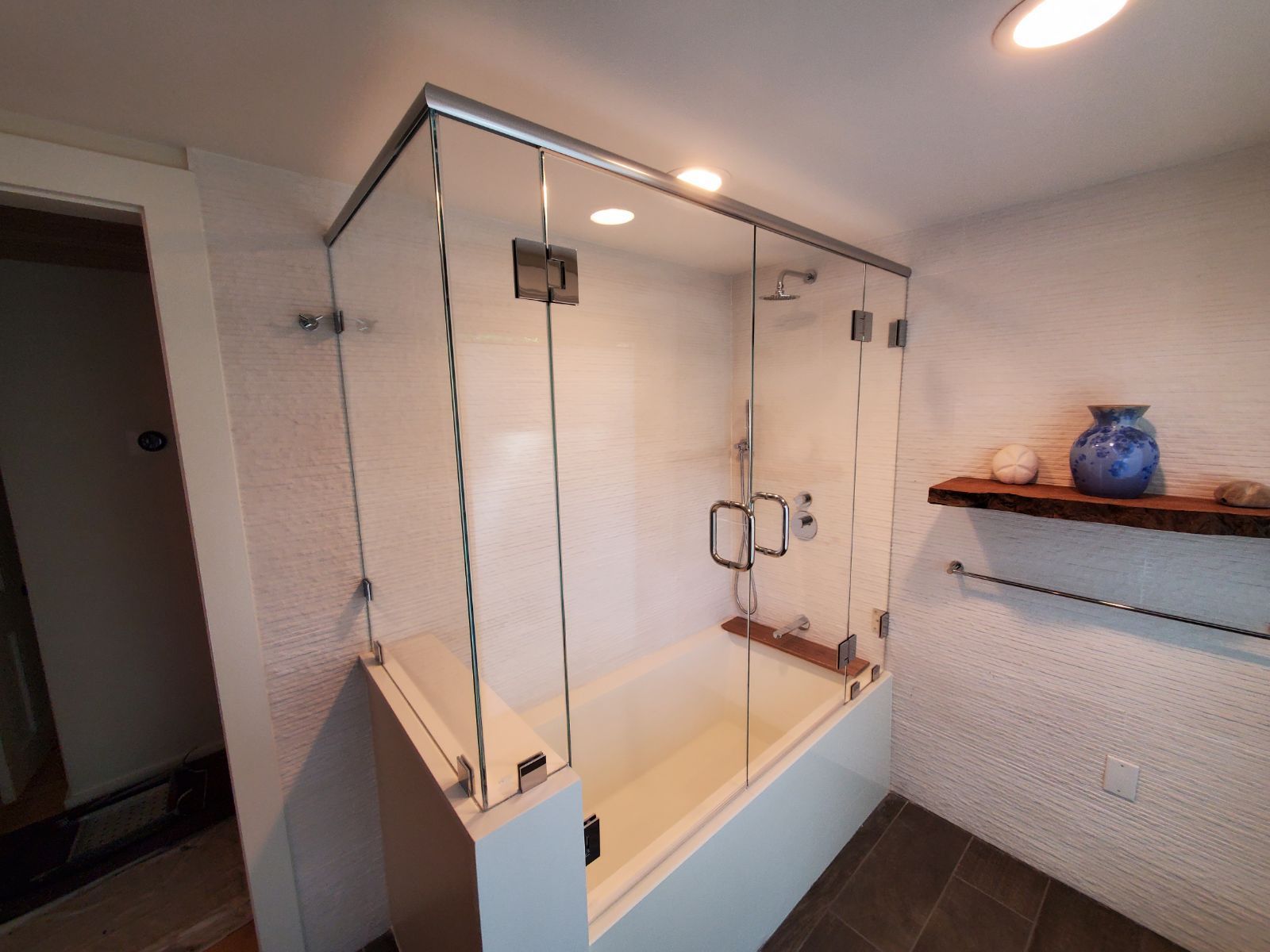 A bathroom with a bathtub and a glass shower door