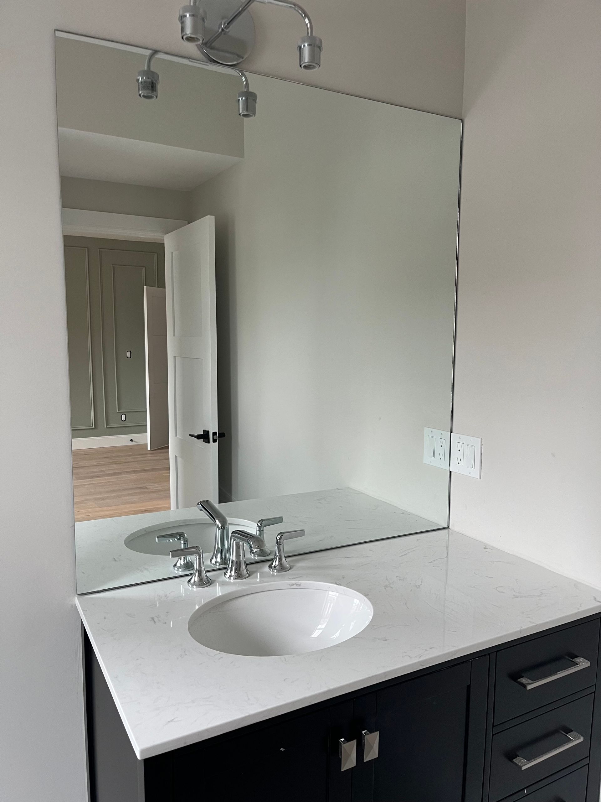 A bathroom sink with a large mirror above it.