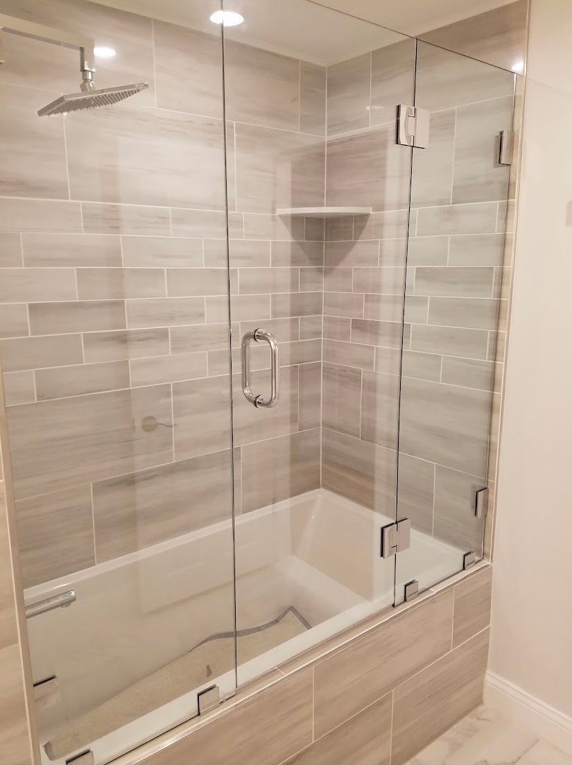 A bathroom with a bathtub and a shower with a glass door.