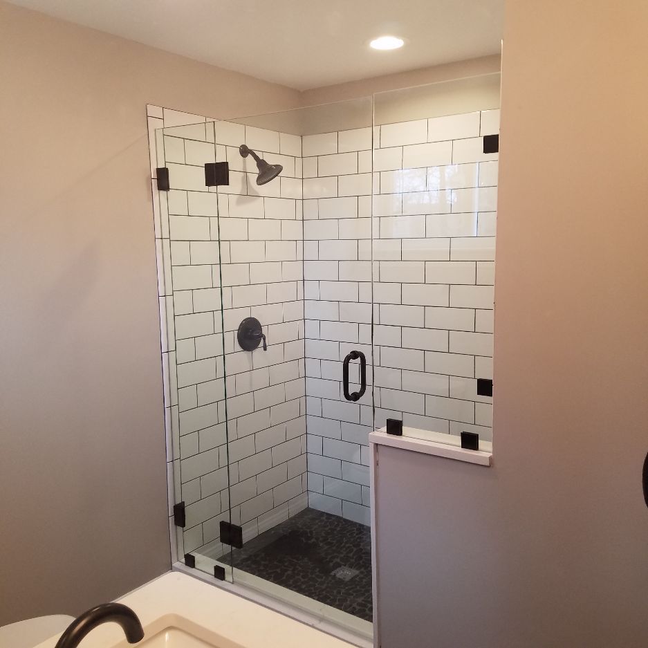 A bathroom with a walk in shower and a sink.