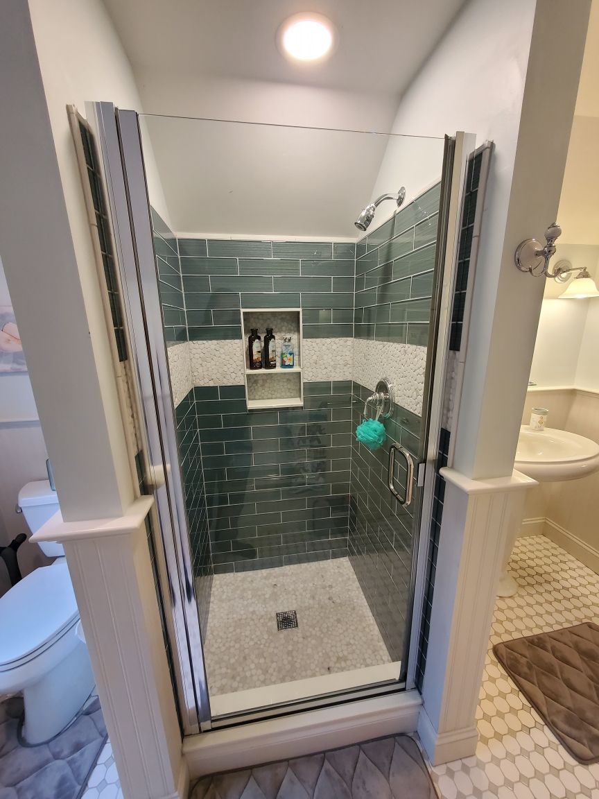A bathroom with a walk in shower and a toilet.
