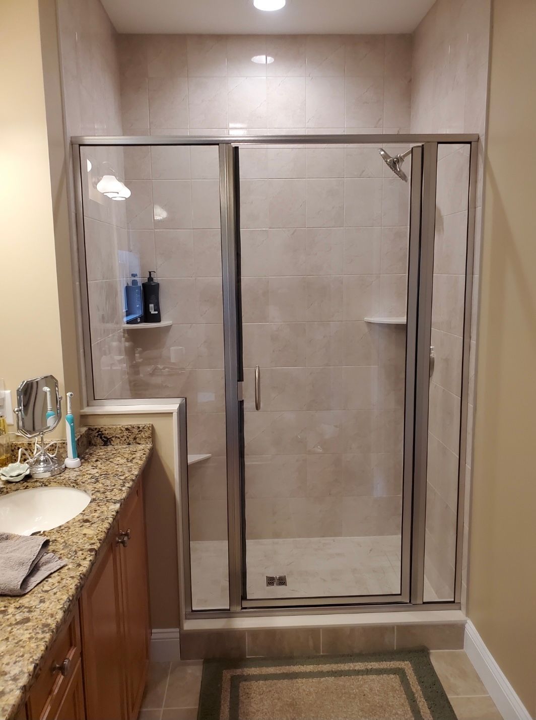 A bathroom with a walk in shower and a sink.