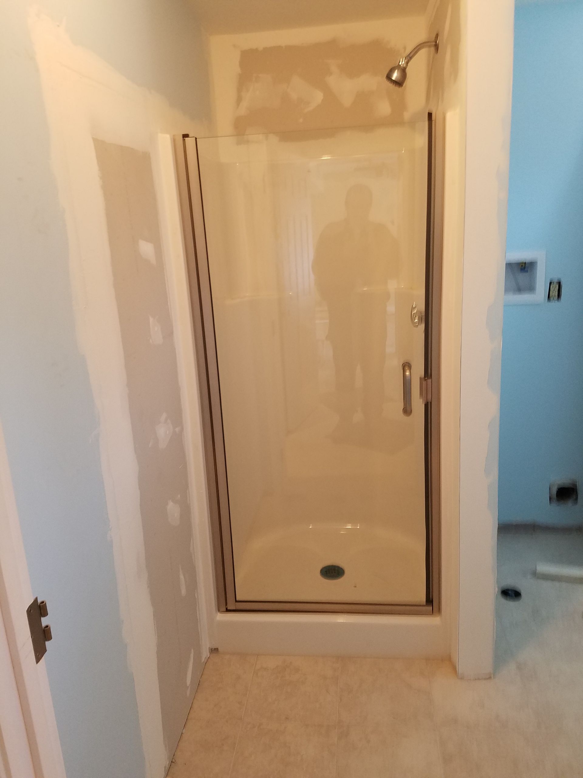 A bathroom with a shower stall and a shower head.