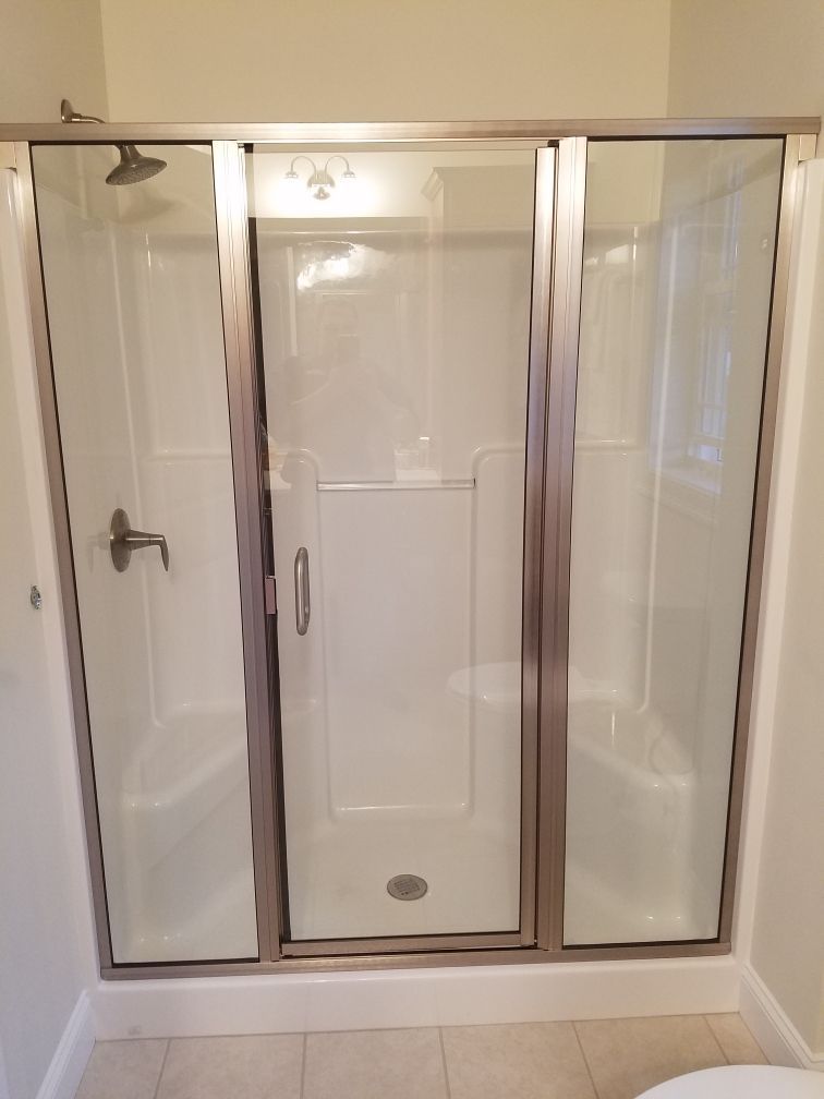 A bathroom with a shower stall and a toilet.