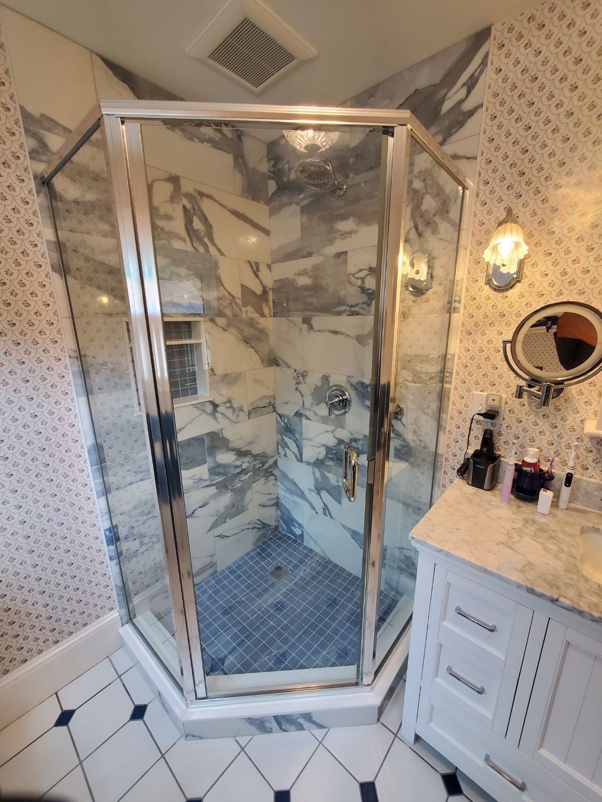 A bathroom with a shower stall and a mirror