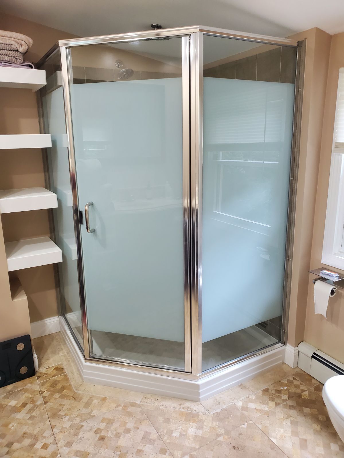 A bathroom with a shower stall and a toilet.