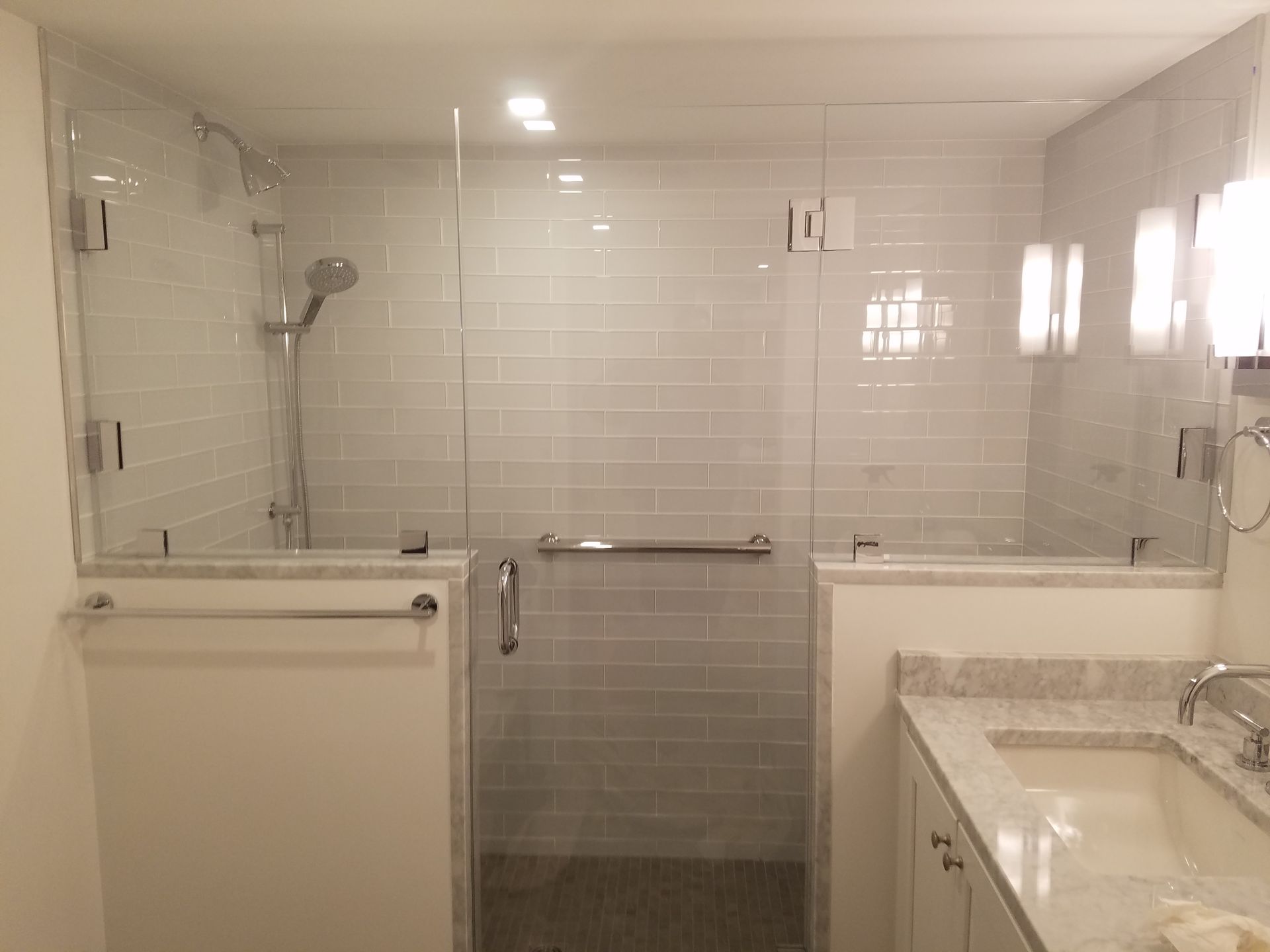 A bathroom with a walk in shower and a sink.