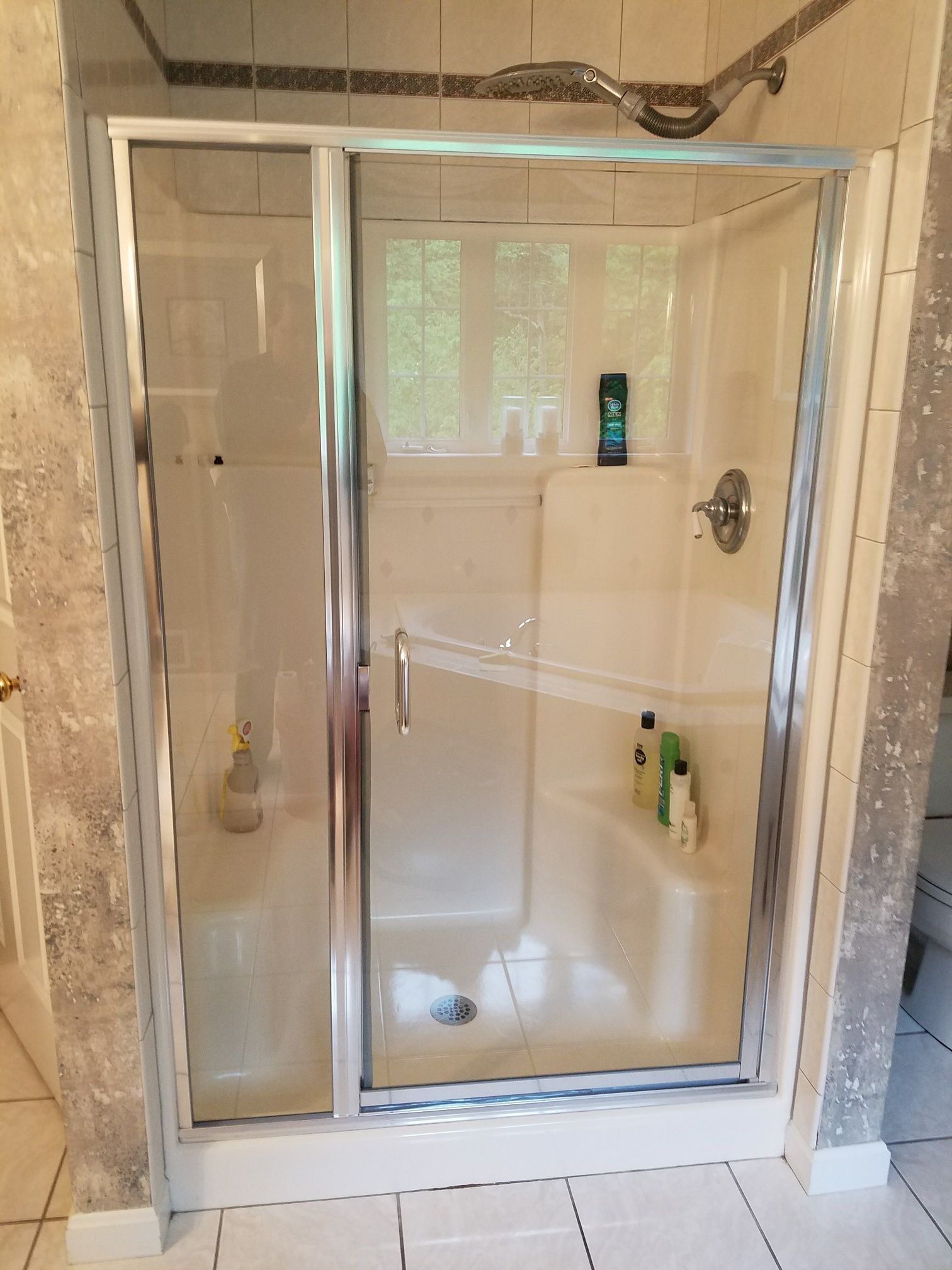 A shower stall with a glass door in a bathroom.