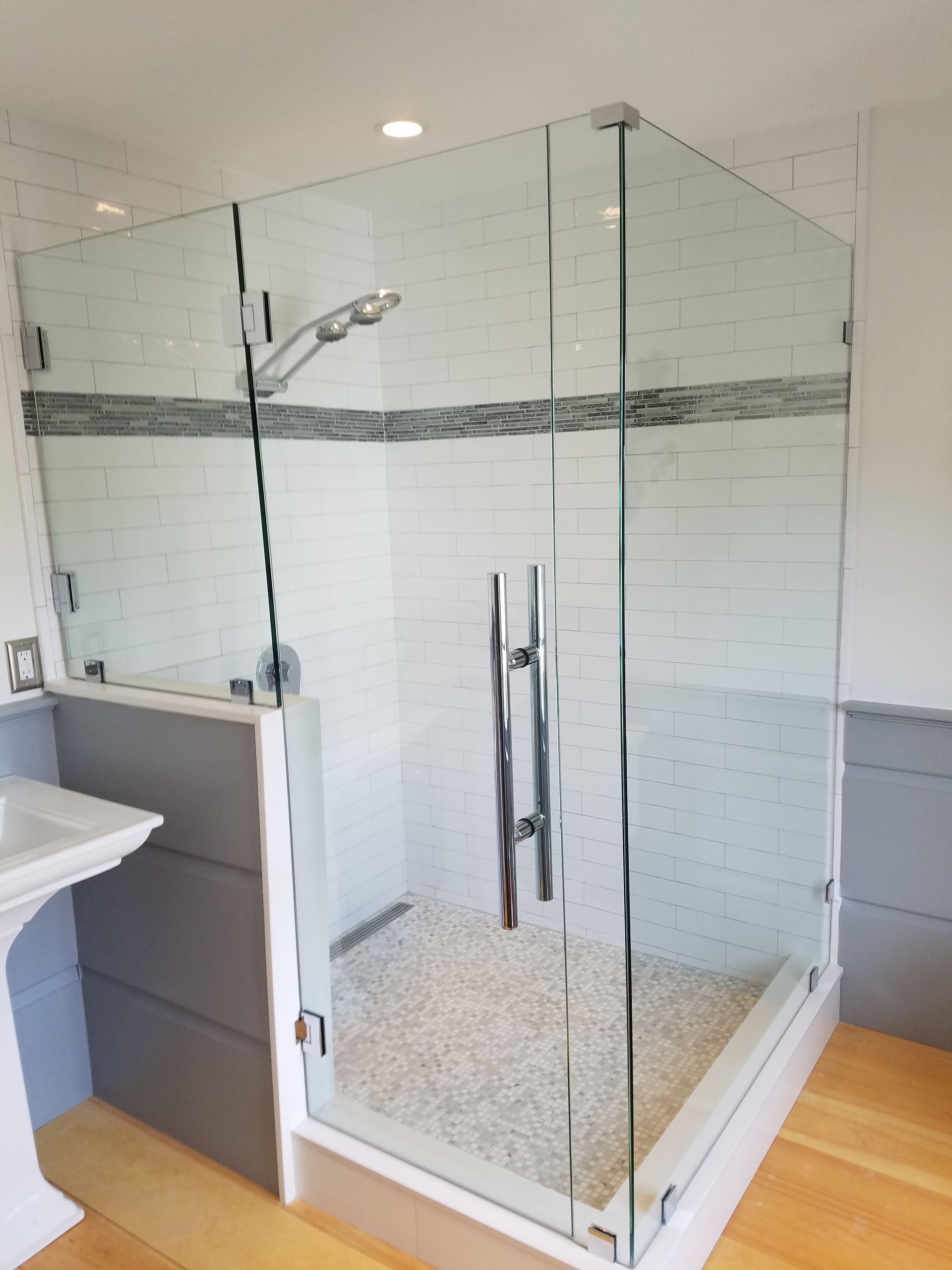 A bathroom with a walk in shower and a sink