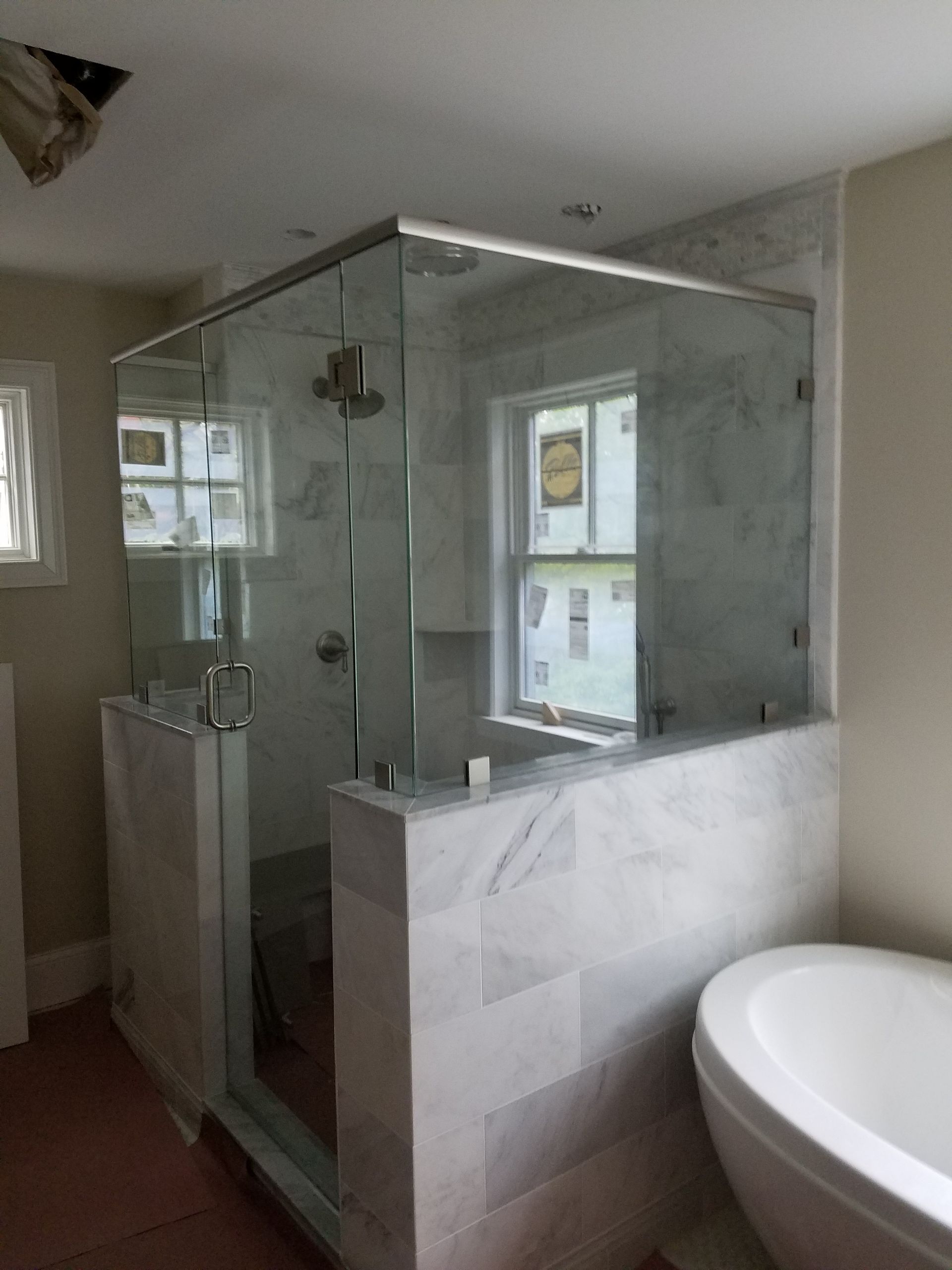 A bathroom with a tub and a shower with a glass door