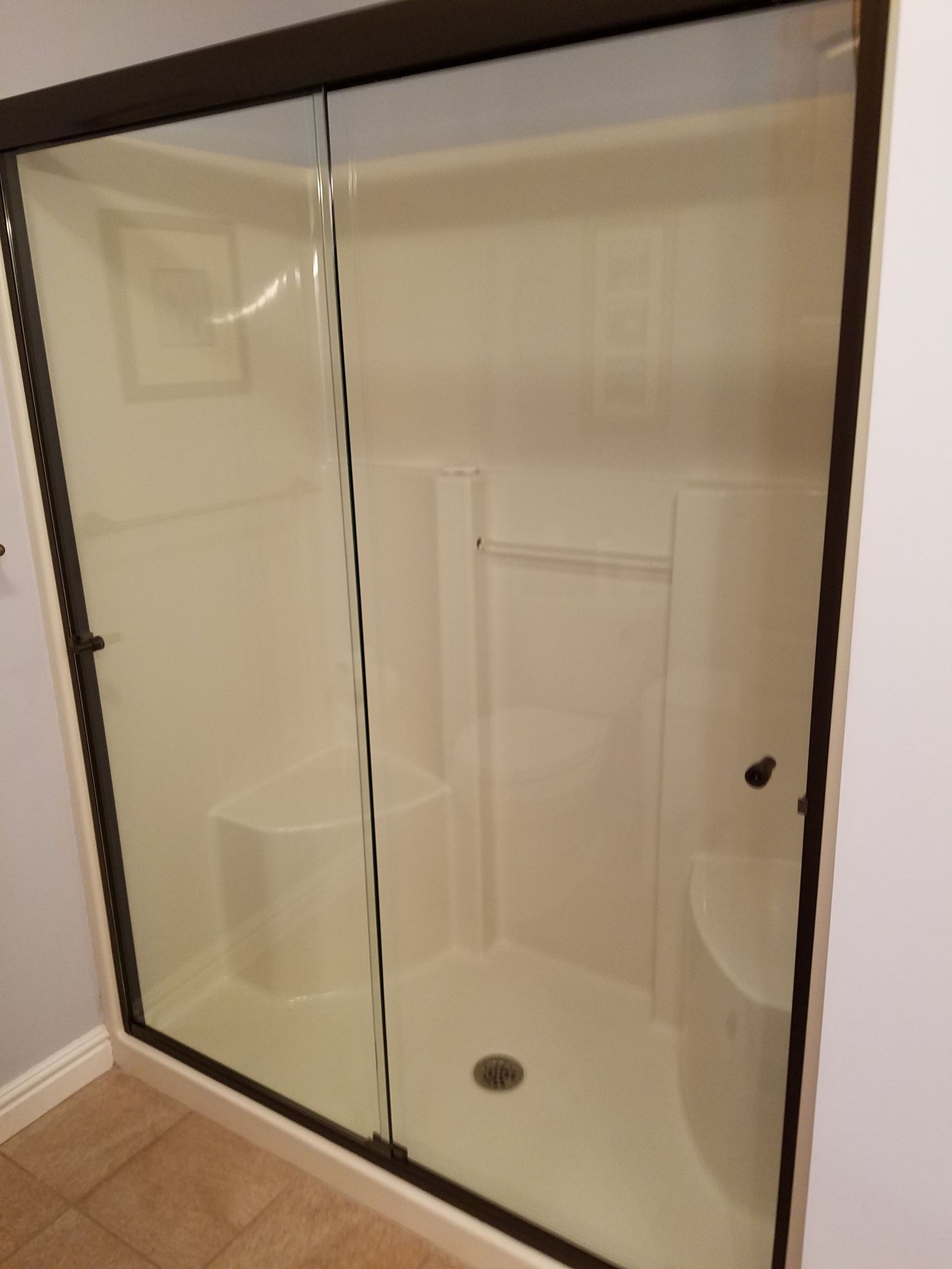 A bathroom with a sliding glass shower door