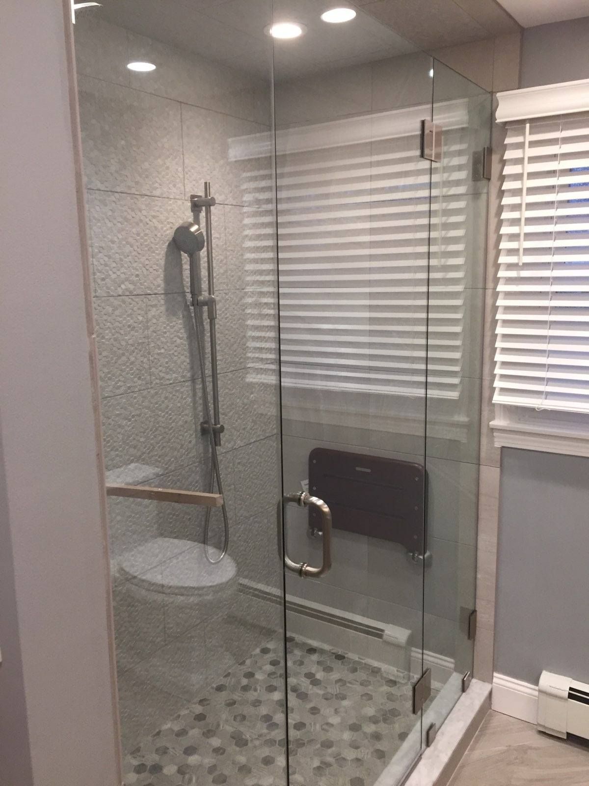 A bathroom with a glass shower door and a toilet.
