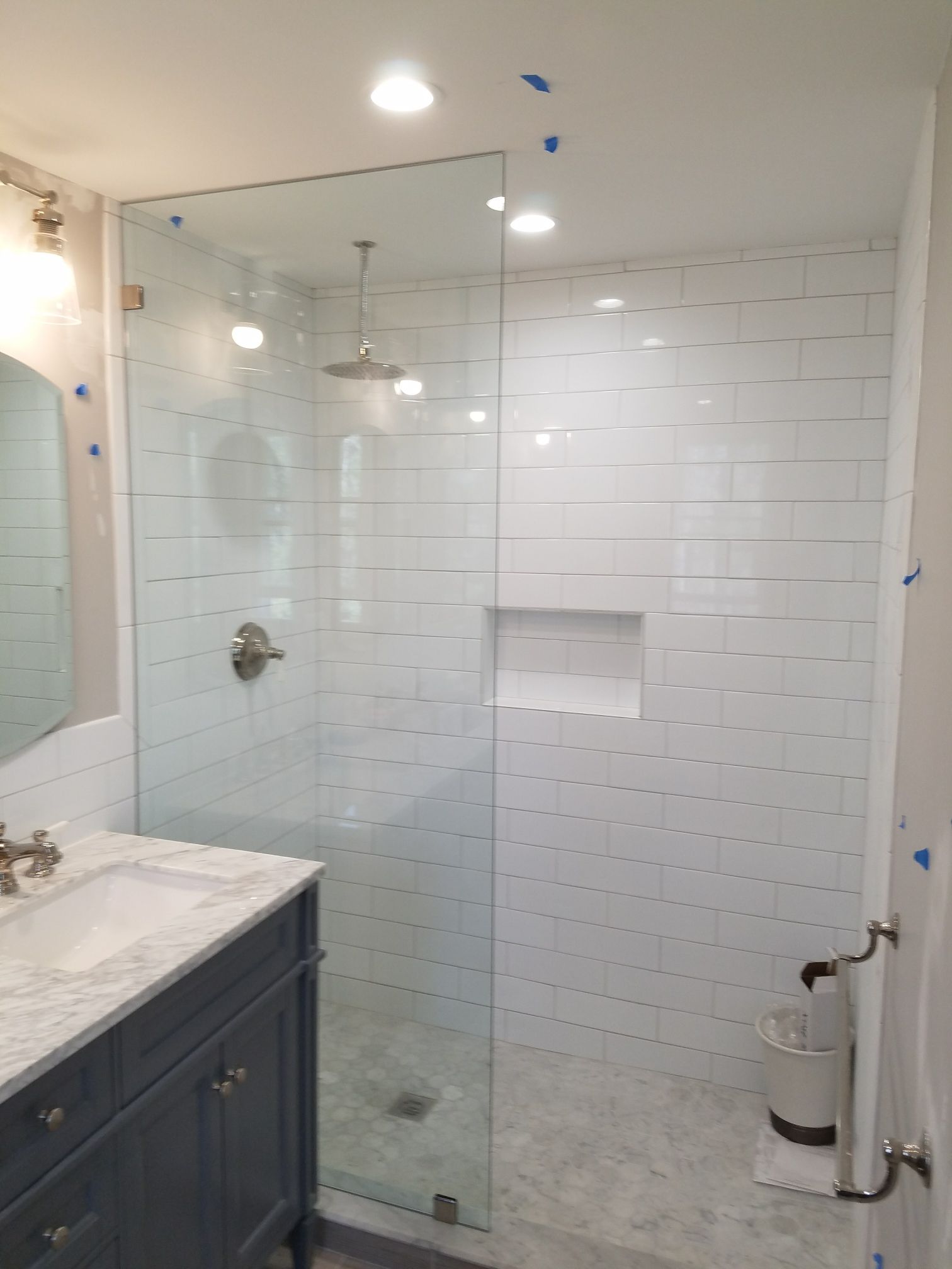 A bathroom with a walk in shower and a sink.