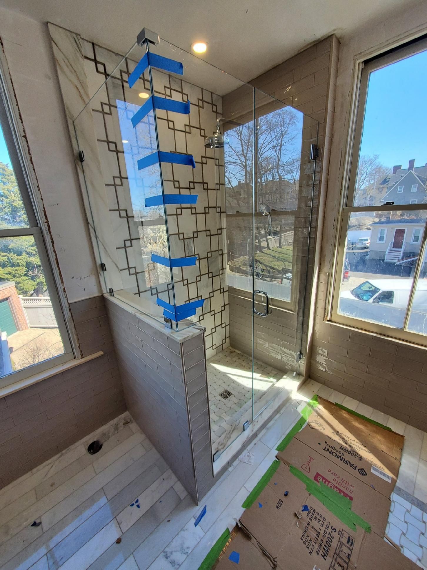 A bathroom with a walk in shower and a window.
