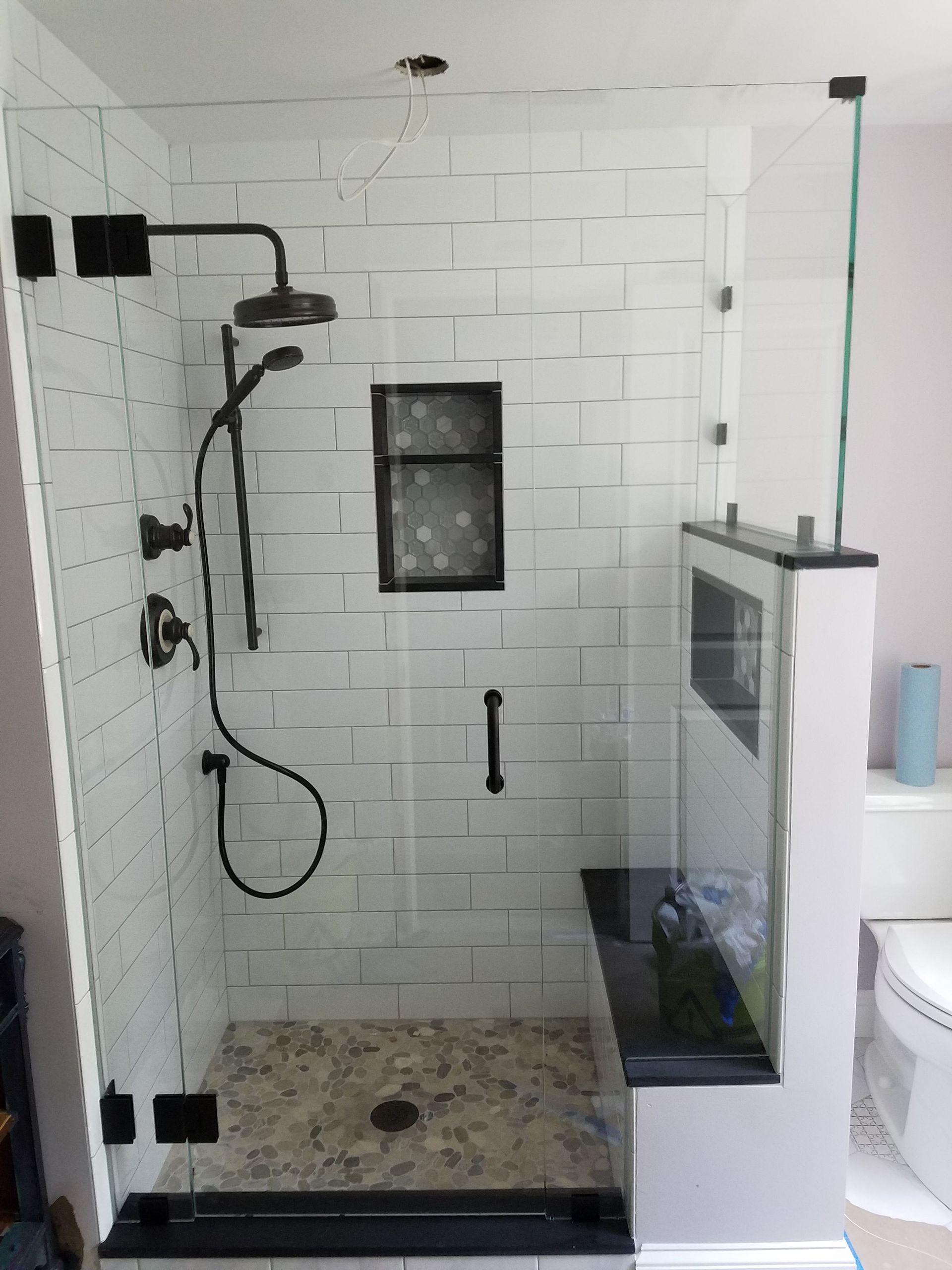 A bathroom with a walk in shower with a glass door