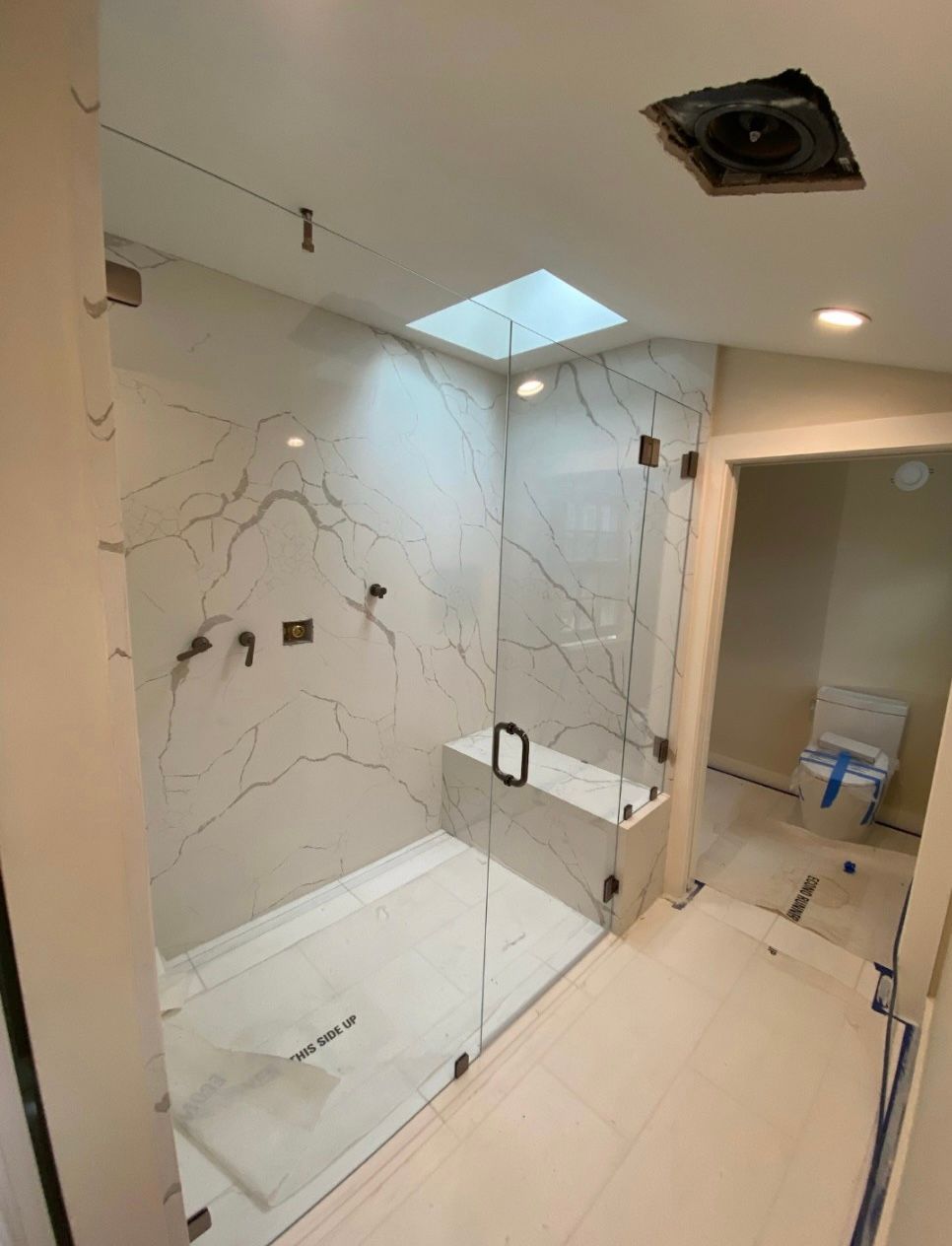 A bathroom with a walk in shower and a toilet.