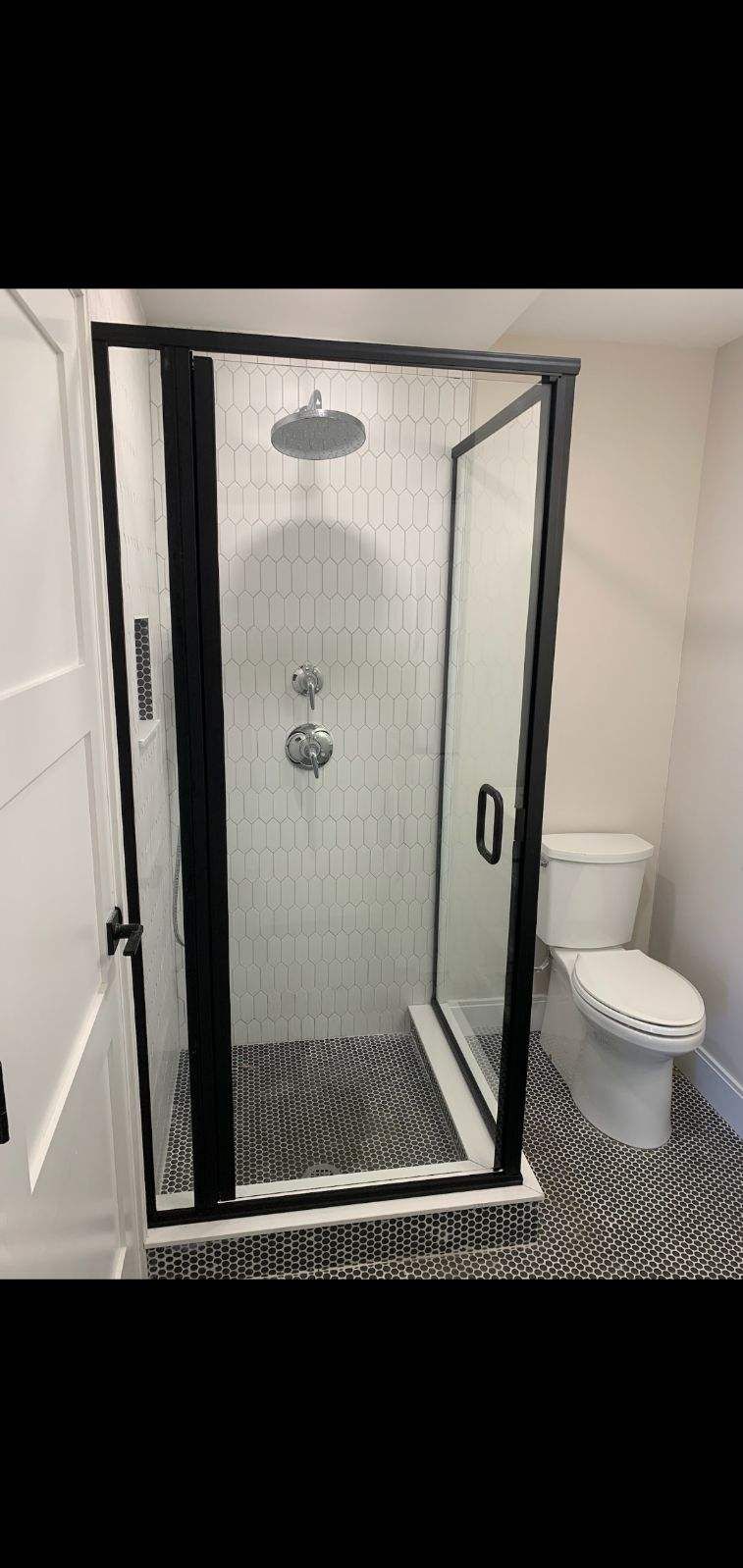 A bathroom with a shower and a toilet.