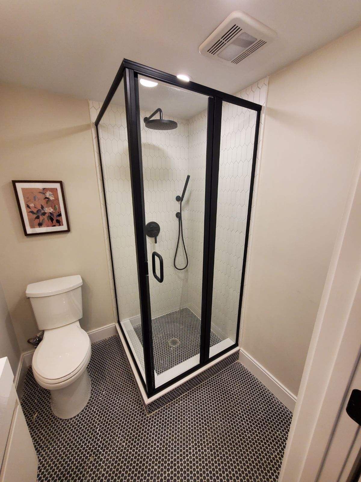 A bathroom with a toilet and a shower stall.